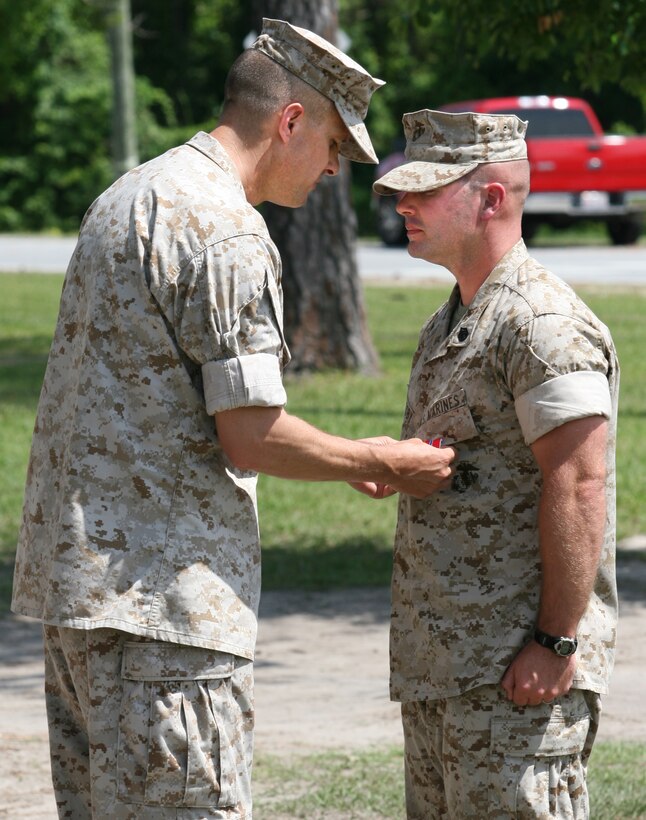 Col. Douglas Thomas, the commanding officer of 10th Marine Regiment, 2nd Marine Division, presents a Bronze Star Medal with combat distinguishing device to Staff Sgt. Philip Crosby, here, June 10.  Crosby earned the award for heroism shown while serving as the assistant effects advisor for Military Transition Team 133, Multinational Force West from Nov. 2007 to Oct. 2008 in support of Operation Iraqi Freedom. (Official U.S. Marine Corps photo by Lance Cpl. John A. Faria) (RELEASED)