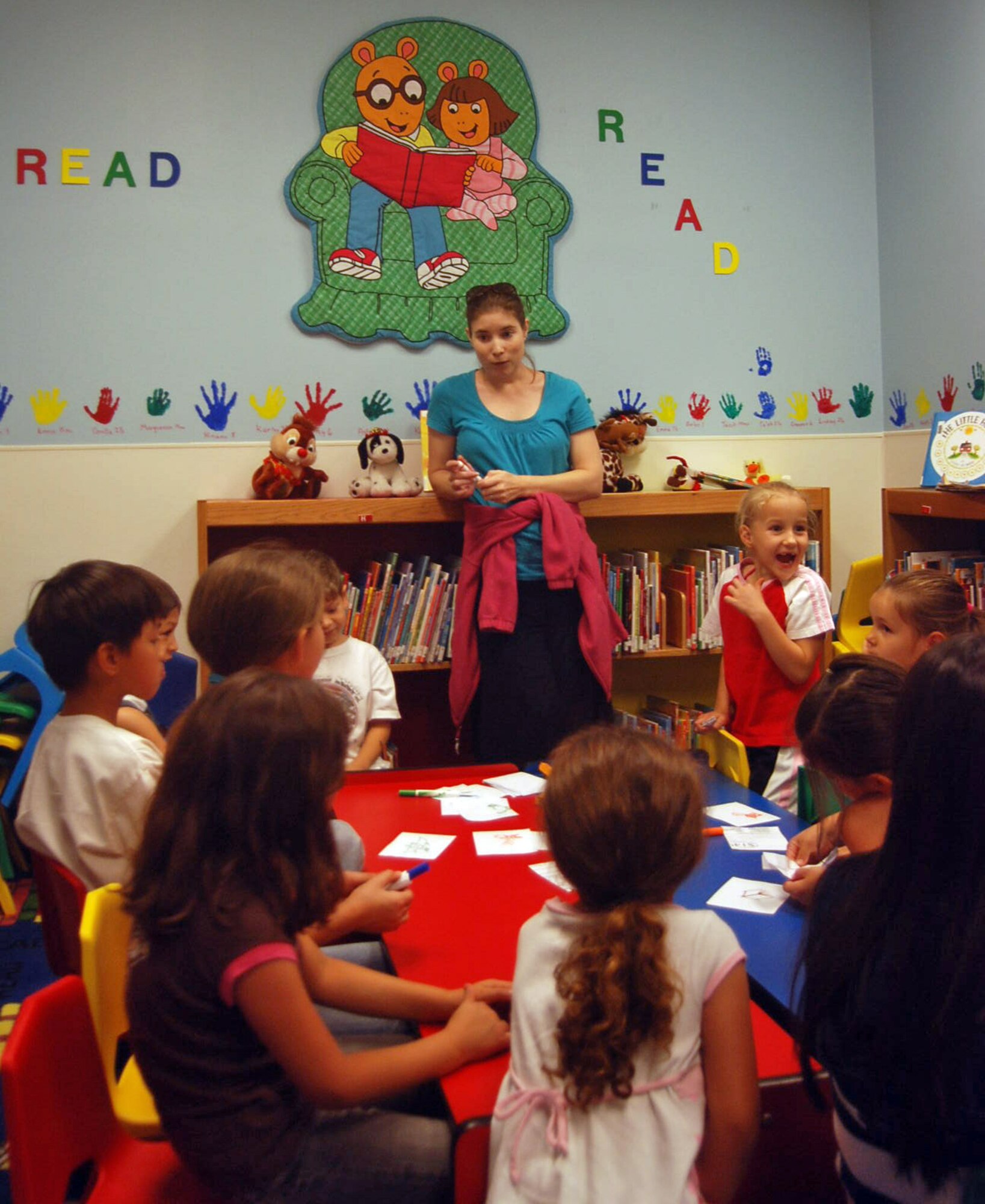 LAUGHLIN AIR FORCE BASE, Texas -- Patricia Ross, library technician at the Book Mark Library, explains the craft activity for June 9’s Summer Reading Program to a group of children. The program is held from 1 until 2 p.m. every Tuesday at the base library. The program is for children 6 to 12 years old and they enjoy a story, make crafts and play games.  The library staff also offers a story time at 10:30 a.m. every Friday. In addition, the library is promoting a summer reading program where children who read for 12 hours or 12 books, depending on age, receive a prize at the end of the summer. (U.S. Air Force photo by Tech. Sgt. Joel Langton)