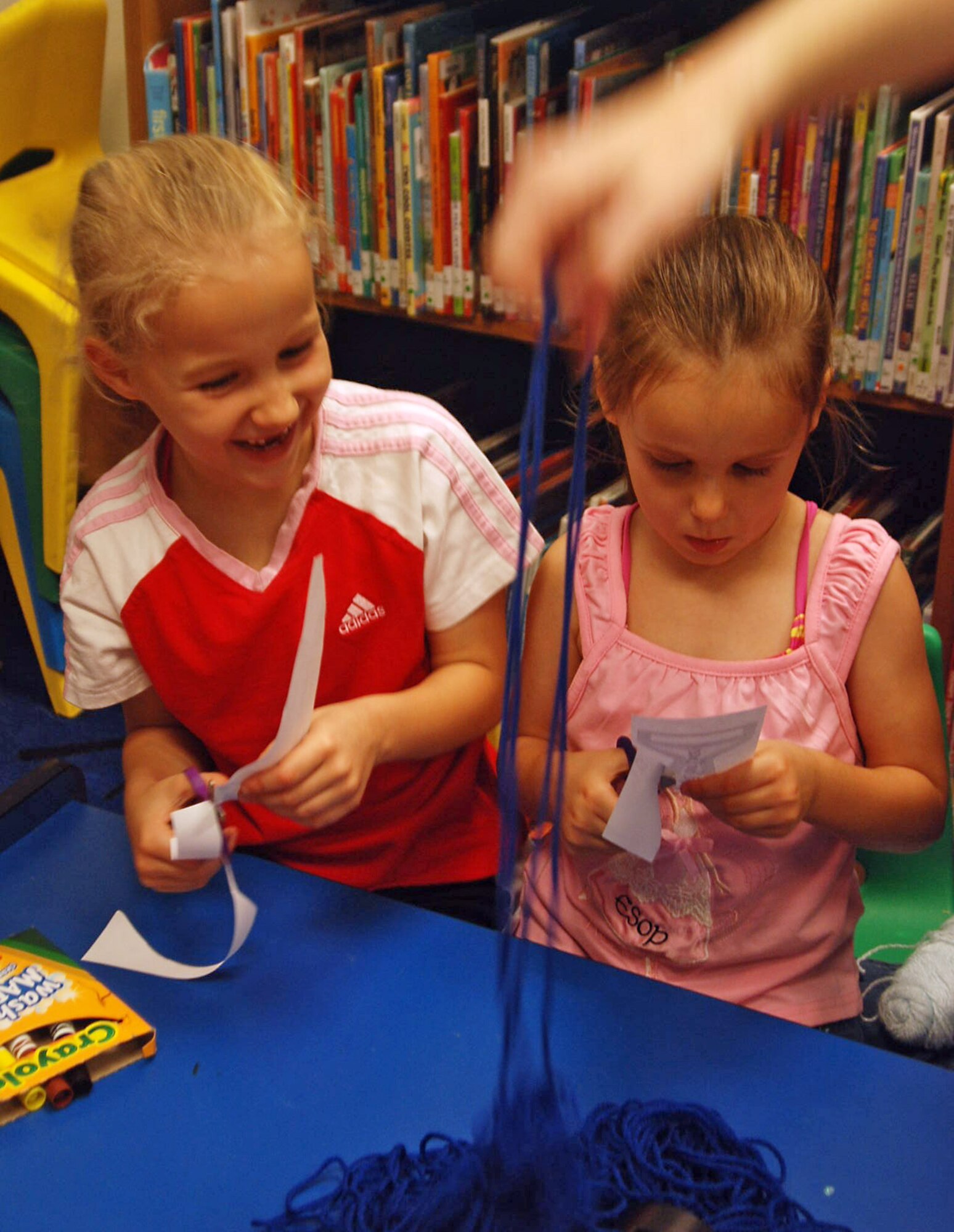 LAUGHLIN AIR FORCE BASE, Texas -- Sisters, Raina, 6, and Kayla Turner, 4, daughters of Leslie and Maj. Jason Turner, 434th Fighter Training Squadron, enjoy the craft activity for June 9’s Summer Reading Program. The program is held from 1 until 2 p.m. every Tuesday at the base library. The program is for children 6 to 12 years old and youngsters enjoy a story, make crafts and play games.  The library staff also offers a story time at 10:30 a.m. every Friday. In addition, the library is promoting a summer reading program where children who read for 12 hours or 12 books, depending on age, receive a prize at the end of the summer. (U.S. Air Force photo by Tech. Sgt. Joel Langton)