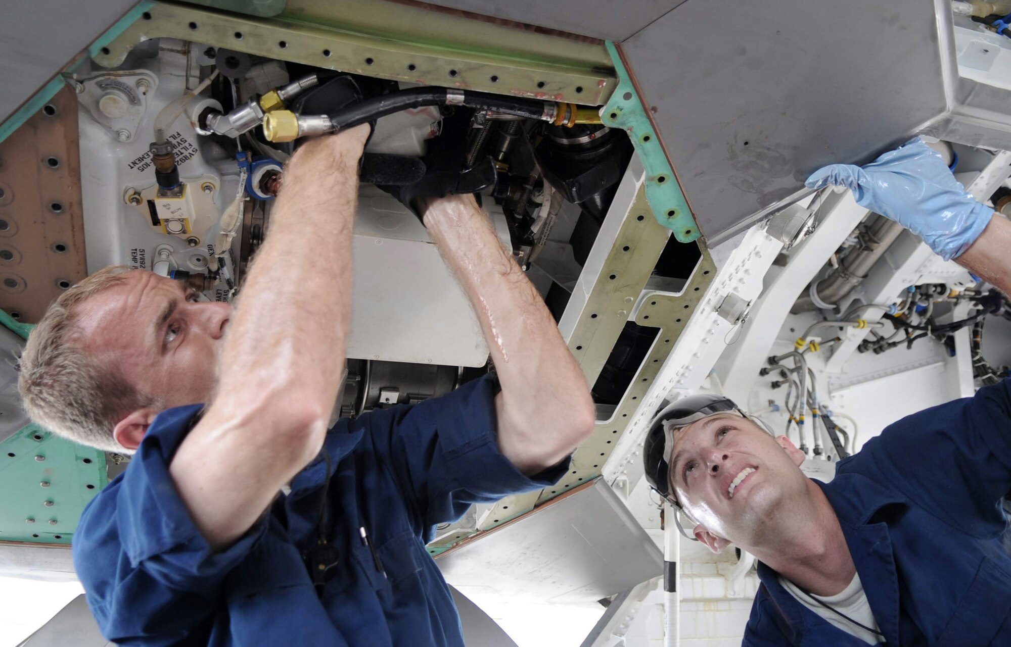 Staff Sgt. Jeremiah Smith and Senior Airman Theodore Cupp perform maintenance on a hydraulic pump June 3. The Airmen are Raptor crew chiefs assigned to the 525th Expeditionary Aircraft Maintenance Unit deployed to Andersen Air Force Base, Guam from Elmendorf Air Force Base, Alaska, in support of U.S. Pacific Command's Theatre Security Packages. (U.S. Air Force photo/Senior Airman Christopher Bush)