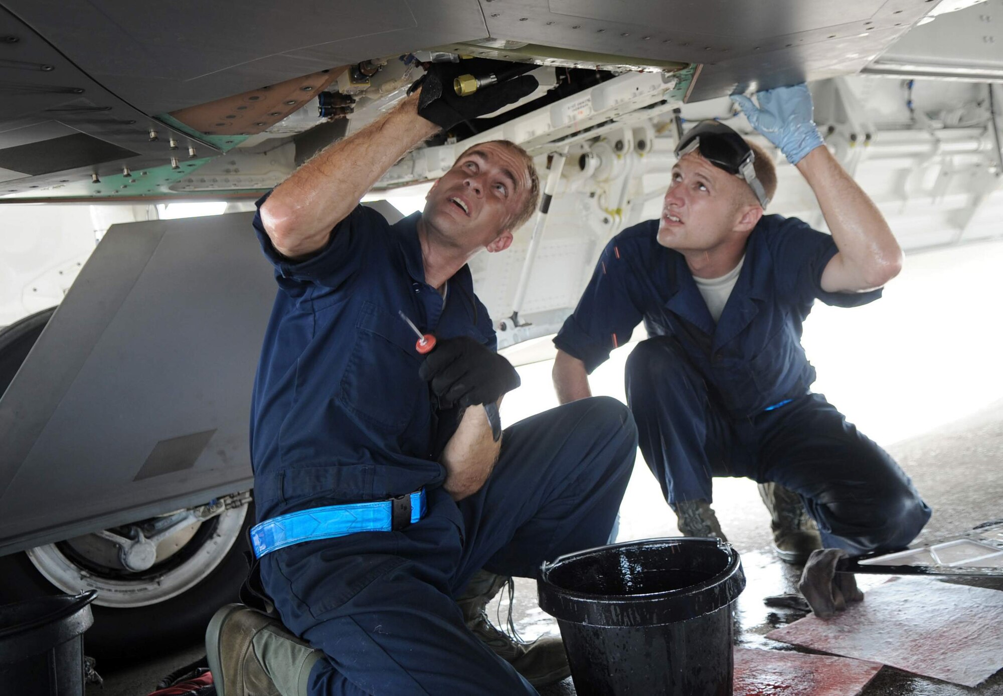 Staff Sgt. Jeremiah Smith and Senior Airman Theodore Cupp, F-22 crew chiefs from the 525th Expeditionary Aircraft Maintenance Unit deployed from Elmendorf Air Force Base, Alaska, perform maintenance on a hydraulic pump June 3. The Airmen are deployed to Andersen Air Force Base, Guam in support of U.S. Pacific Command's Theatre Security Packages. (U.S. Air Force photo/Senior Airman Christopher Bush)