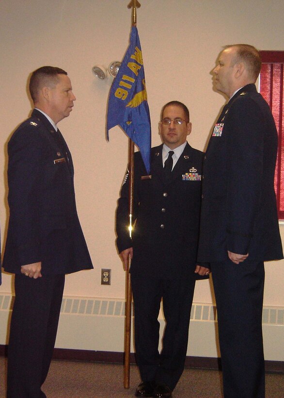 Col. James B. Hurley, 911th Mission Support Group commander and presiding officer for the Assumption of Command, prepares to hand the unit flag to Maj. James M. Klein during the ceremony held here, March 7, 2009.