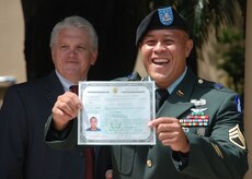 TEGUCIGALPA, Honduras - U.S. Army Staff Sgt. Damien Milne shows off his certificate of U.S. citizenship following his naturalization in a formal ceremony at the U.S. embassy here June 10.  Sergeant Milne is from the Marshall Islands.  He is a two-time Iraq war veteran and is currently assigned to Joint Task Force-Bravo's 1st Battalion, 228th Aviation Regiment.  His ceremony here was the first U.S. naturalization ceremony to take place in Central America.  (U.S. Air Force
photo/Tech. Sgt. Rebecca Danét)

