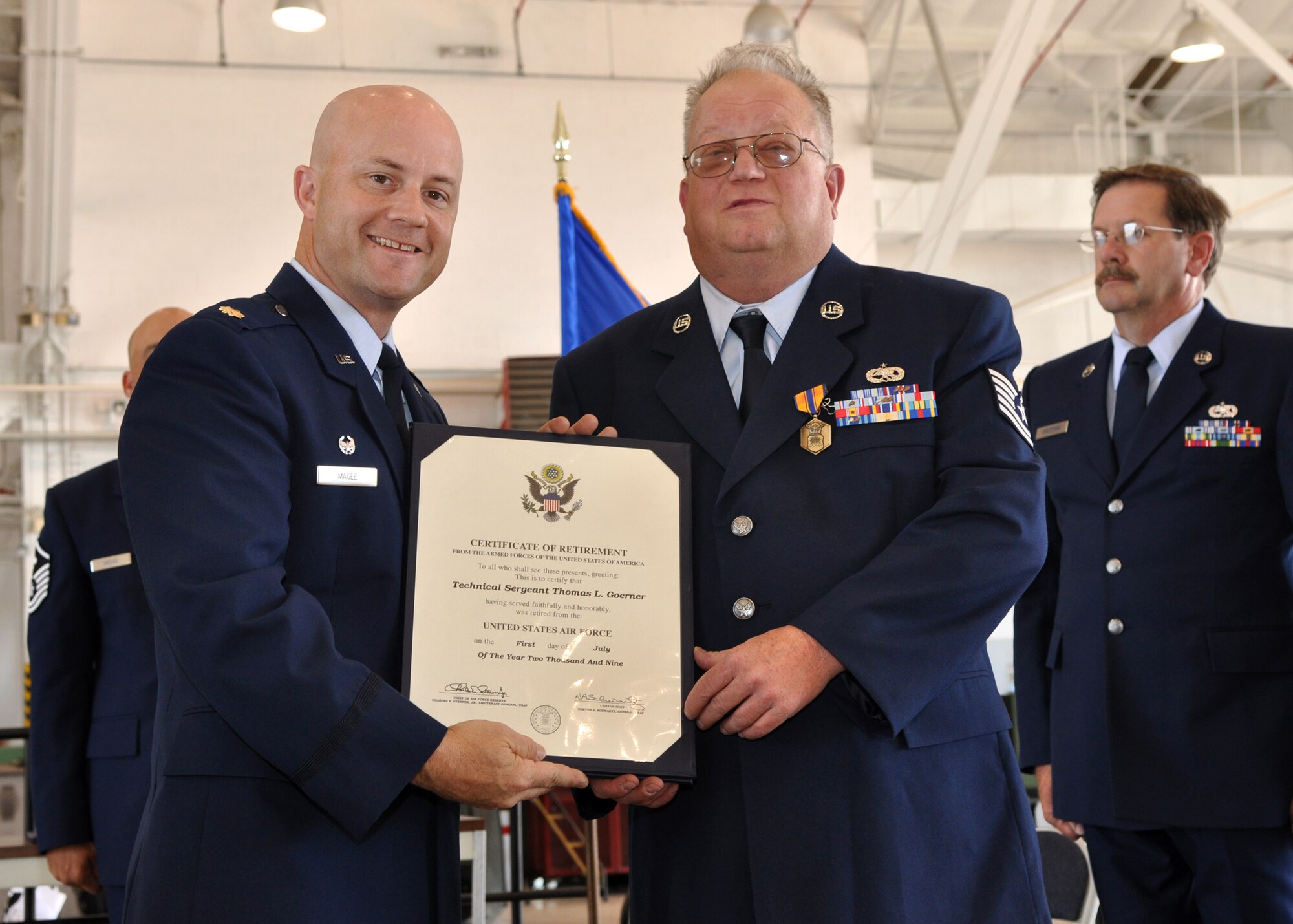 Technical Sgt. (Ret) Thomas Goerner receives his retirement certificate from Maj. William Magee, 917th Maintenance Squadron, commander, during one of the retirement ceremonies held in the A-10 Hangar at Barksdale Air Force Base, La., June 6, 2009. Sergeant Goerner is one of three Airmen from the 917th Wing who retired on the anniversary of the D-Day invasion of June 6, 1944. The retirements mean a loss of more than 101 years of total experience to the 917th Wing. Technical Sgt. Goerner retired after 33 years of service. Also retiring were Master Sgt. Sterling “Pete” Bretzman with 37 years of service and Master Sgt. James Guggenheim with 31.5 years of service. (U.S. Air Force photo/Tech. Sgt. Jeff Walston)    