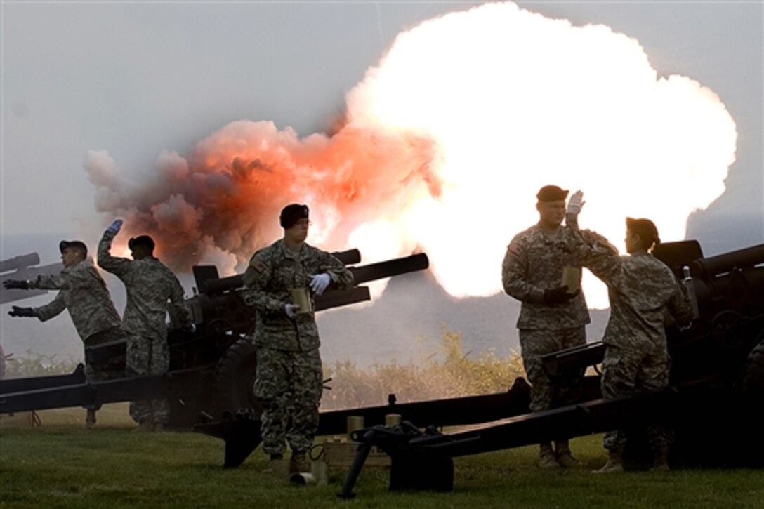 A U.S. Army salute battery team fires a ceremonial M119A1 105mm Lightweight Towed Howitzer overlooking Omaha Beach on the Normandy American Cemetery and Memorial, Normandy, France, June 6, 2009. The soldiers are assigned to the 529 Military Police Company.