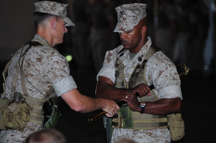 Marine Aviation Logistics Squadron 12 commanding officer Lt. Col. Jonathan O. Gackle passes the sword to Master Gunnery Sgt. Maurice Patterson during the MALS-12 post-and-relief ceremony here June 11. Sgt. Maj. James C. Kirkland was relieved by Master Gunnery Sgt. Maurice Patterson after serving as the MALS-12 squadron sergeant major since July of 2006.