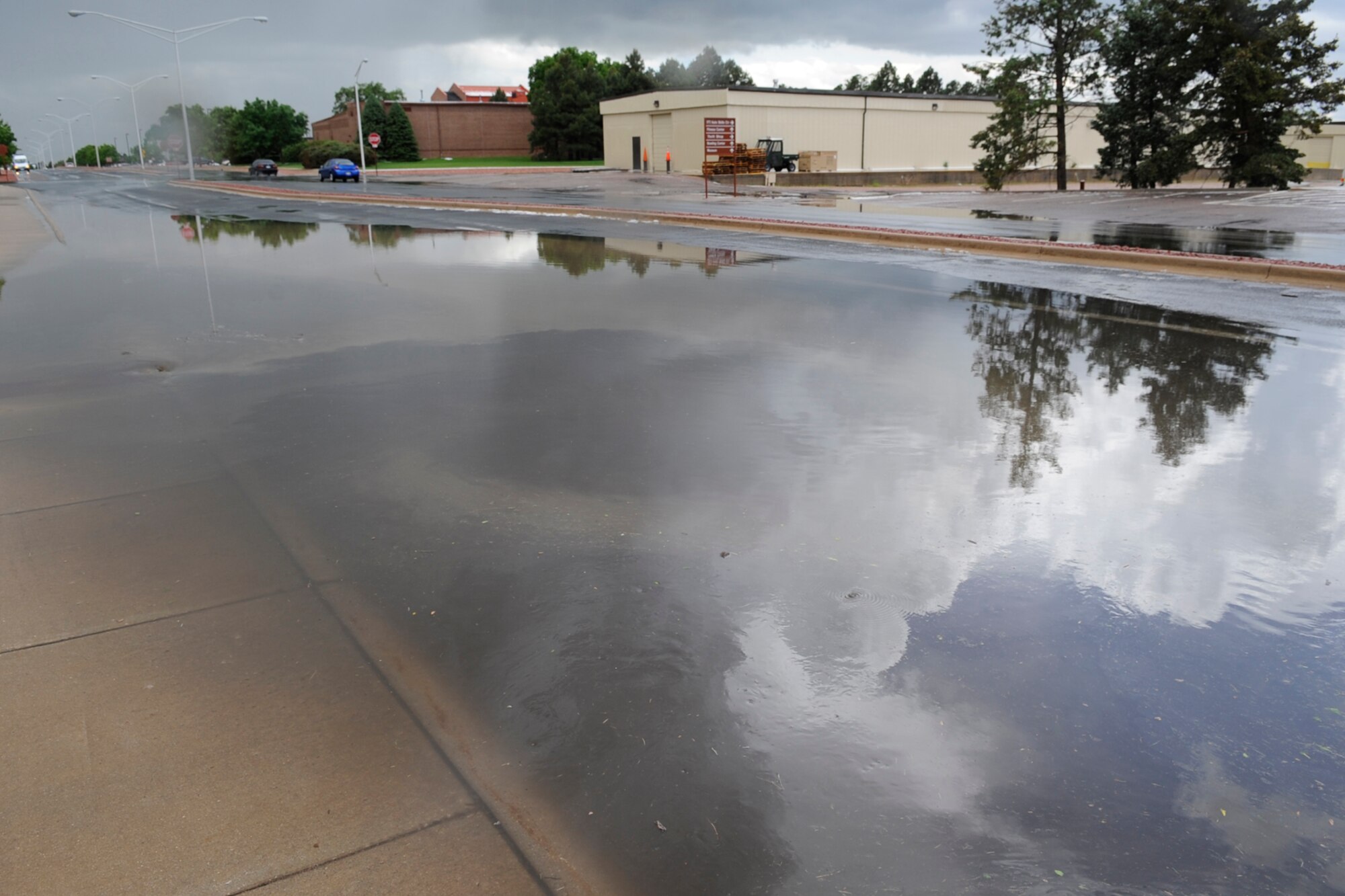A large rain puddle covering Ent Street, near the intersection of Otis Street, was left in the wake of a short but powerful hailstorm that pounded Peterson at approximately 2 p.m., June 11. Following the storm, drivers and pedestrians were forced to contend with puddles and gravel-sized hail. There were no reports of any base damage caused by the squall. (Air Force photo by Rob Bussard).  
