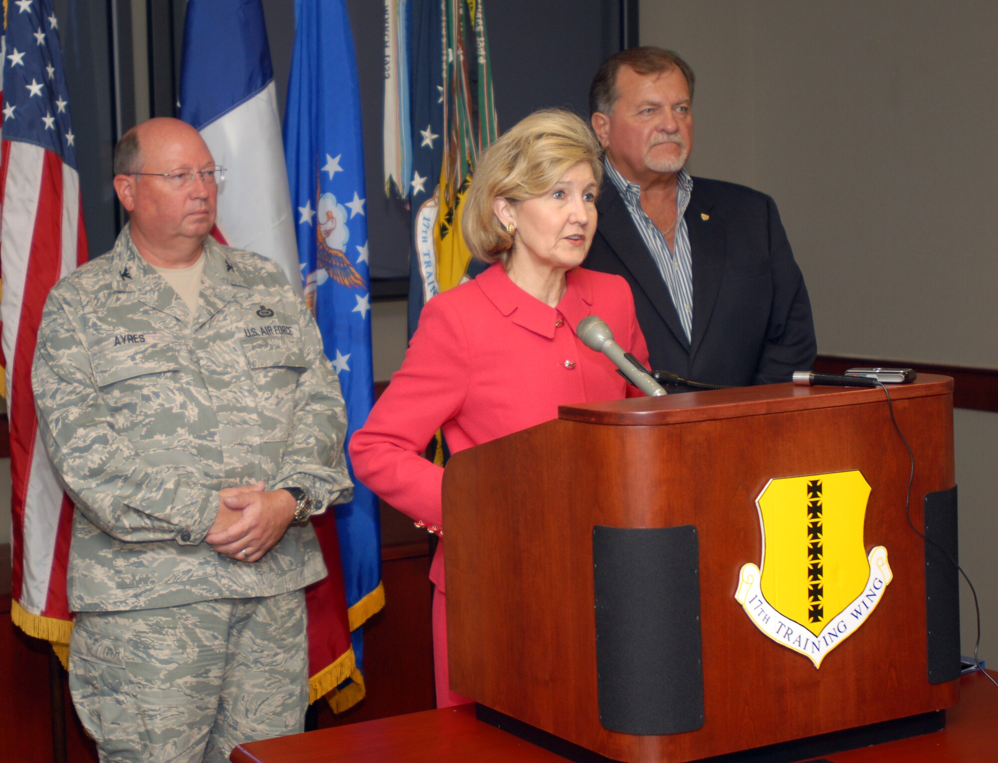 Colonel Richard Ayres, 17th Training Wing commander, and Mike Brown, Tom Green County Judge, listen as United States Senator Kay Bailey Hutchison addresses local media and wing leadership Saturday. Senator Hutchison received a briefing on MILCON projects, dormitories, the chapel, consolidated learning center and intelligence complex during her visit. (U.S. Air Force photo by Airman Clayton Lenhardt)