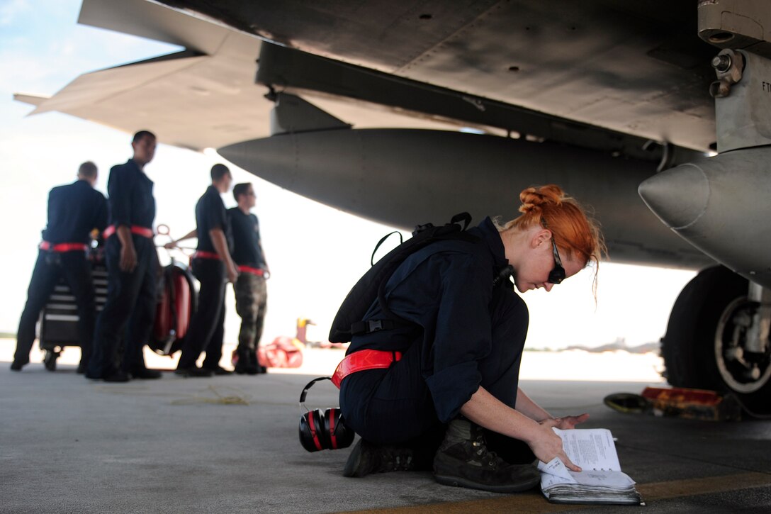 LANGLEY AIR FORCE BASE, Va. --  Airman 1st Class Jessica Hinves, 71st Fighter Squadron crew chief, reviews an F-15 technical order book during a Phase I Operational Readiness Exercise here June 12. The Phase I ORE was conducted to test and prepare Airmen for future deployments. (U.S. Air Force photo/Senior Airman Vernon Young)