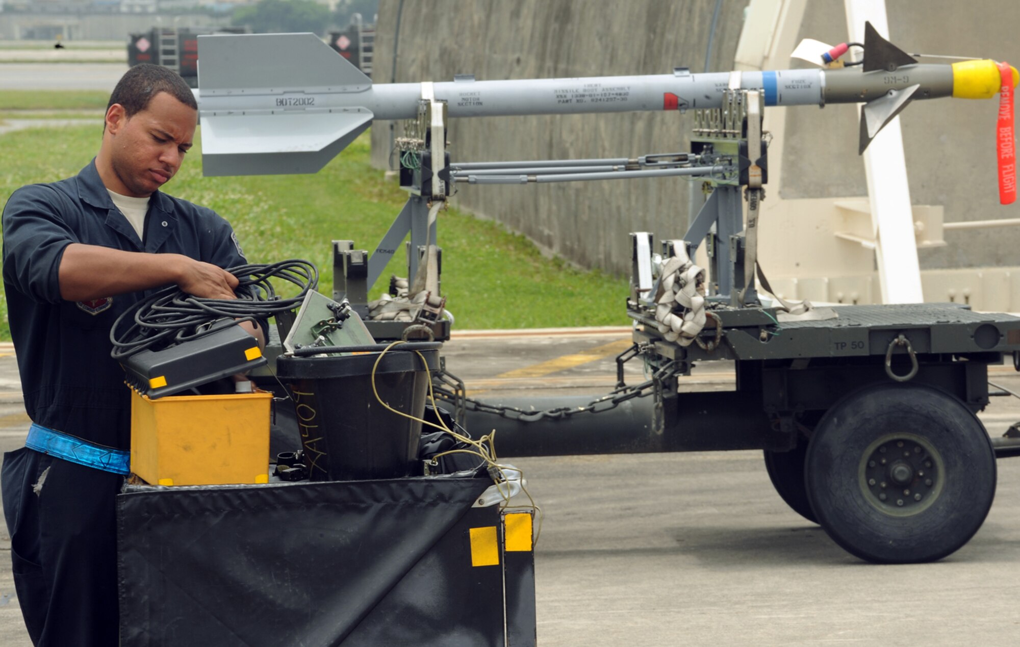 LANGLEY AIR FORCE BASE, Va.  -- Airman Kian Bridgett, a 94th Aircraft Maintenance Unit crew chief, straightens up tools after completing a post flight inspection of the F-22A Raptor at Kadena Air Base, Japan, June 3. More than 280 Airmen from the 94th Fighter Squadron, Virginia Air National Guard 192nd Fighter Wing, and 94th Aircraft Maintenance Unit deployed to Kadena as part of a Western Pacific theater security package May 26. (U.S. Air Force photo/Airman 1st Class Jarrod Chavana)
