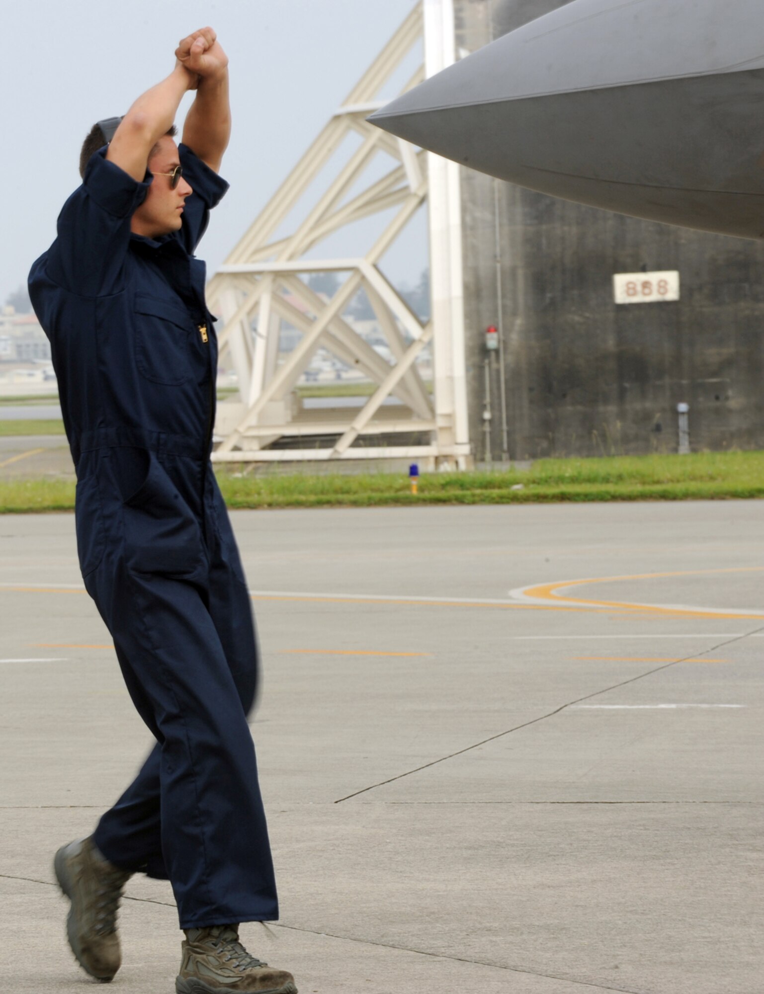 LANGLEY AIR FORCE BASE, Va. -- Staff Sgt. Ryan Rogers,  Virginia Air National Guard 192nd Fighter Wing crew chief, signals to an F-22A Raptor pilot to put on full break after a sortie at Kadena Air Base, Japan, June 2. More than 280 Airmen from the 94th Fighter Squadron, Virginia Air National Guard 192nd Fighter Wing, and 94th Aircraft Maintenance Unit deployed to Kadena as part of a Western Pacific theater security package May 26. (U.S. Air Force photo/Airman 1st Class Jarrod Chavana)

