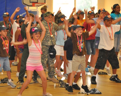 Children participating in Operation Junior R.A.P.T.O.R. perform some jumping jacks for physical training before their "deployment" June 12 at Tyndall Air Force Base, Fla. The purpose of the day was to give children an idea of what their military parents have to do when deploying abroad; the event was sponsored by the Airman and Family Readiness Center. (U.S. Air Force photo/Staff Sgt. Joshua Stevens)
