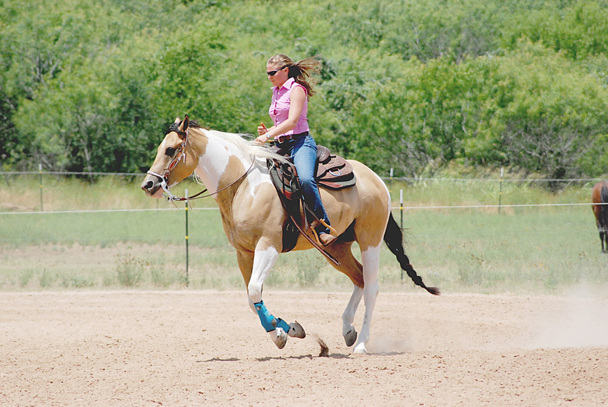 Staff Sgt. Courtney Linde kicks up some dirt with her paint horse, ?Toby,? during a recent ride. Sergeant Linde, whose right femur has been replaced by a titanium rod due to bone cancer, doesn?t let it slow her down. She shows her horse and one of her dogs in competitions. She is also a master scuba diver and a kayaker. (Photo by Marine Gunnery Sgt. Nate Smith)