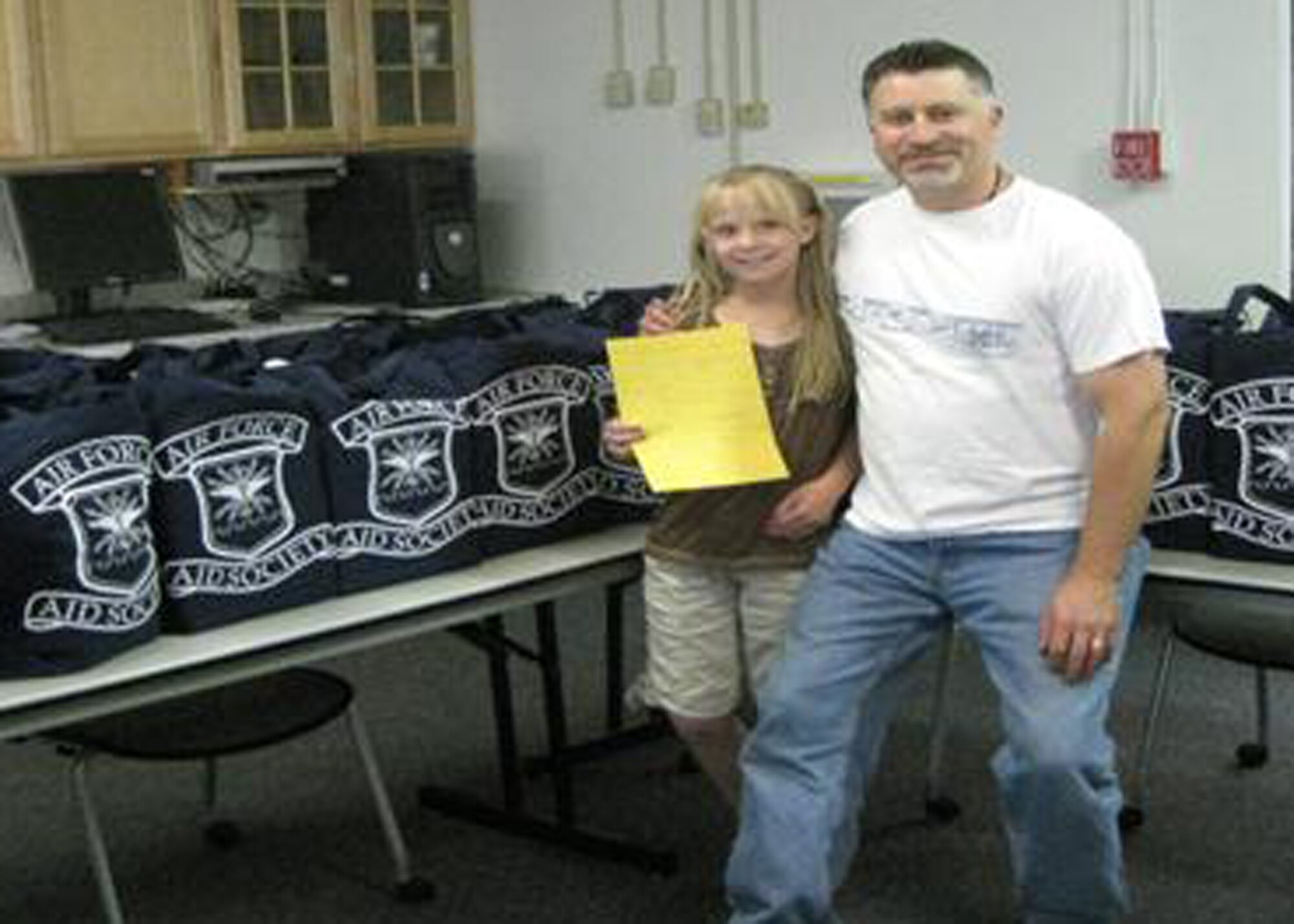 Ashley Breen, Edwards 2009 junior miss and Darrel Burns, Airman and Family Readiness Center chief pose for a picture during a recent community outreach project. Ashley recently assisted personnel at the Family Readiness Center here prepare diaper bags for families. The project helped displaced foster babies and families in need. (Courtesy photo) 
