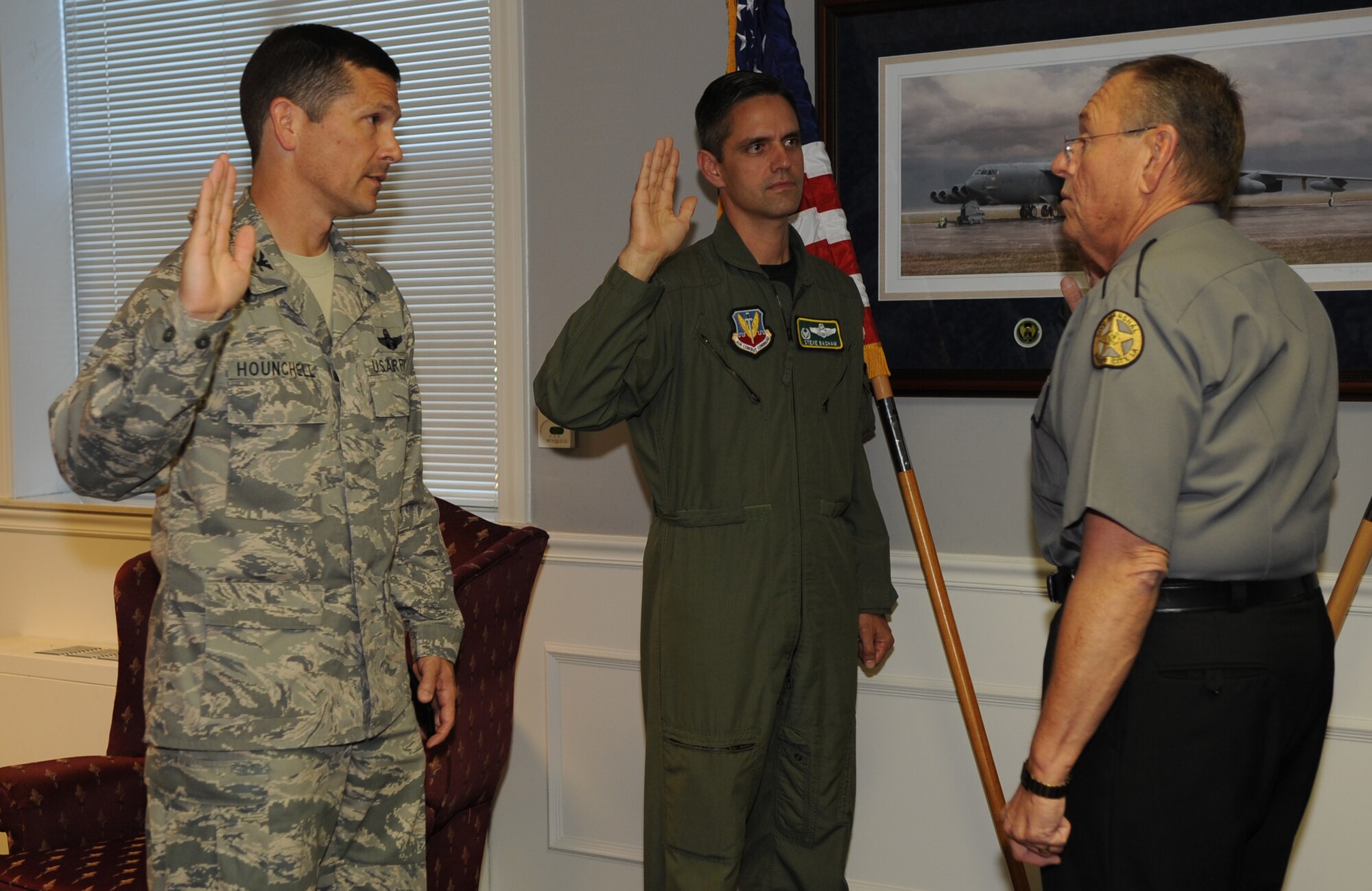 Col. Steven Basham, 2d Bomb Wing, commander, and Col. Gerald Hounchell, 2d Bomb Wing vice commander, are being sworn as Bossier Parish City Marshals by Johnny Wyatt, Bossier Parish City Marshal June 5. (United States Air Force photo by Senior Airman Alexandra Sandoval) 
