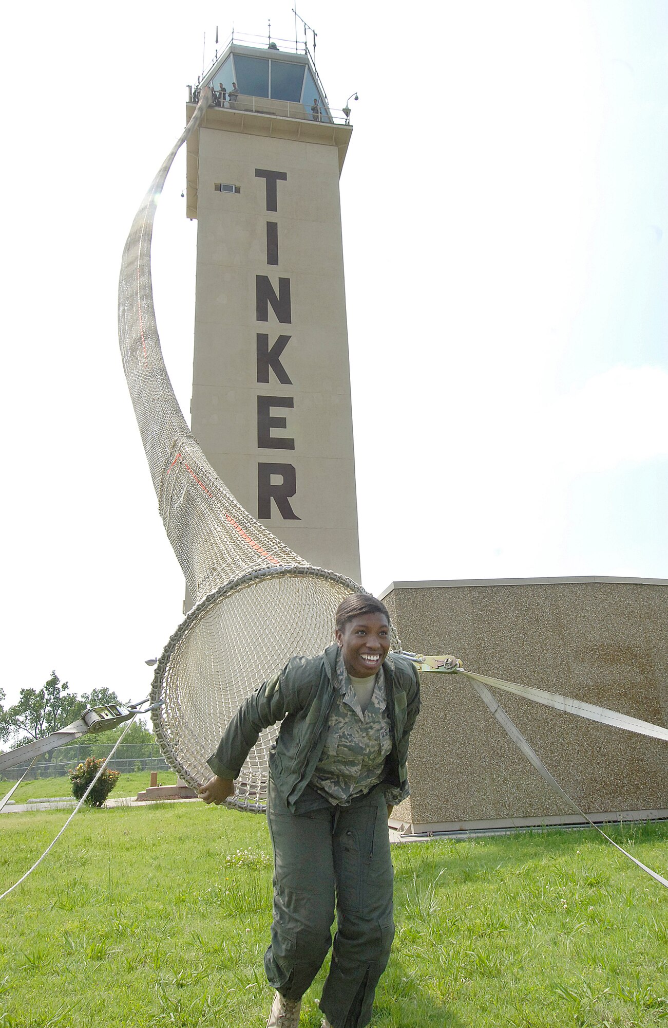 After an annual qualification jump, Senior Airman Angela Huguley exits the Baker Life Chute at the Tinker Air Traffic Control Tower. (Air Force photo/Margo Wright) 