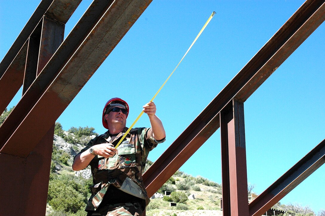 Master Sgt. David Luciano measures twice to cut once along the U.S.-Mexico border near Campo, Calif.