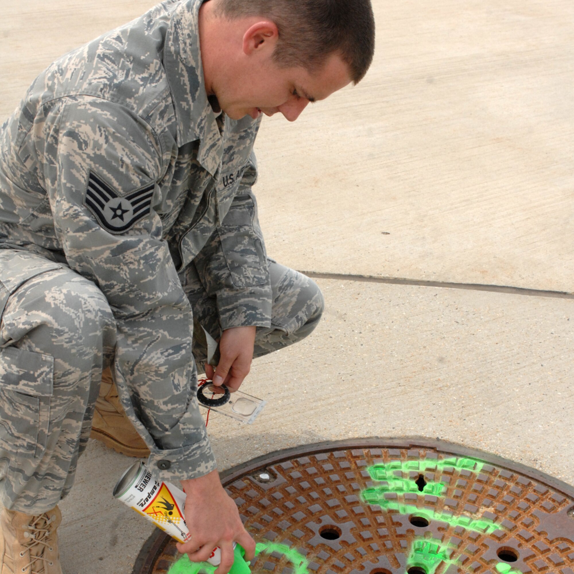 SPANGDAHLEM AIR BASE, Germany -- Staff Sgt. Andrew Camp, 52nd Operations Support Squadron mission weather forecaster, paints directional markings on the alternate observing location for weather forecasters behind the Air Mobility Command Passenger Terminal Fire Department June 11.  Sergeant Camp marked the alternate location so weather observers have another place to view the weather and determine visibility for aircraft in case of an emergency. (U.S. Air Force photo by Senior Airman Jenifer H. Calhoun)