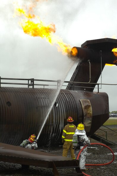 Airmen from the 193rd Special Operations Wing's Fire Department work on extinguishing a fire in the tail engine of the simulator aircraft at Joint Base McGuire-Dix-Lakehurst, N.J.  Their trip to McGuire was a part of their annual training requirements to gain experience with a live fuel fire.