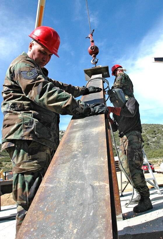 Tech. Sgt. Bill Meiser, 201st REDHORSE Squadron, carefully fits an I-beam into place while his team members weld it in place.  (Photo by Capt. Jay Ostrich)