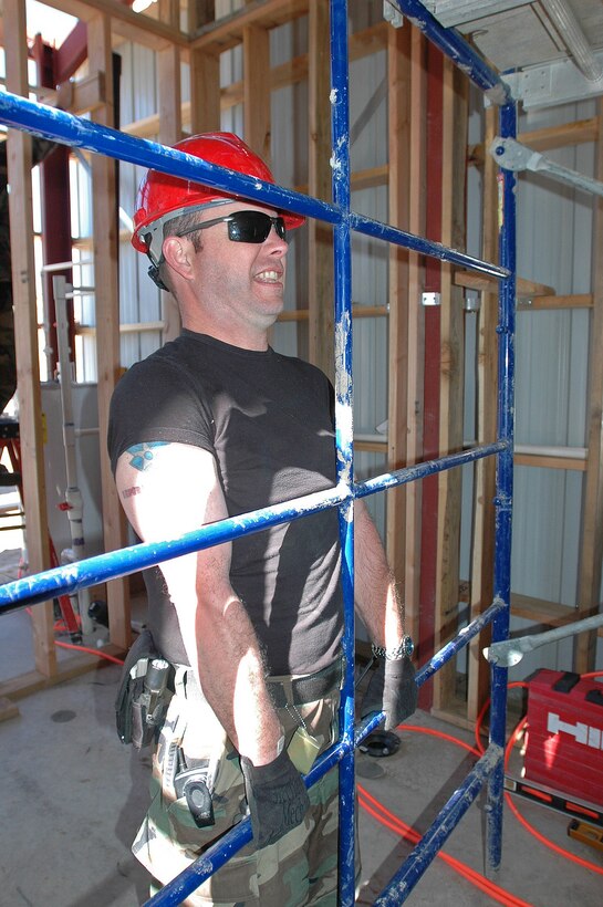 Master Sgt. Chip Koons, facility manager for the 201st REDHORSE Squadron, grits his teeth while safely moving scaffolding for a new facility building near Campo, Calif.  (Photo by Capt. Jay Ostrich)