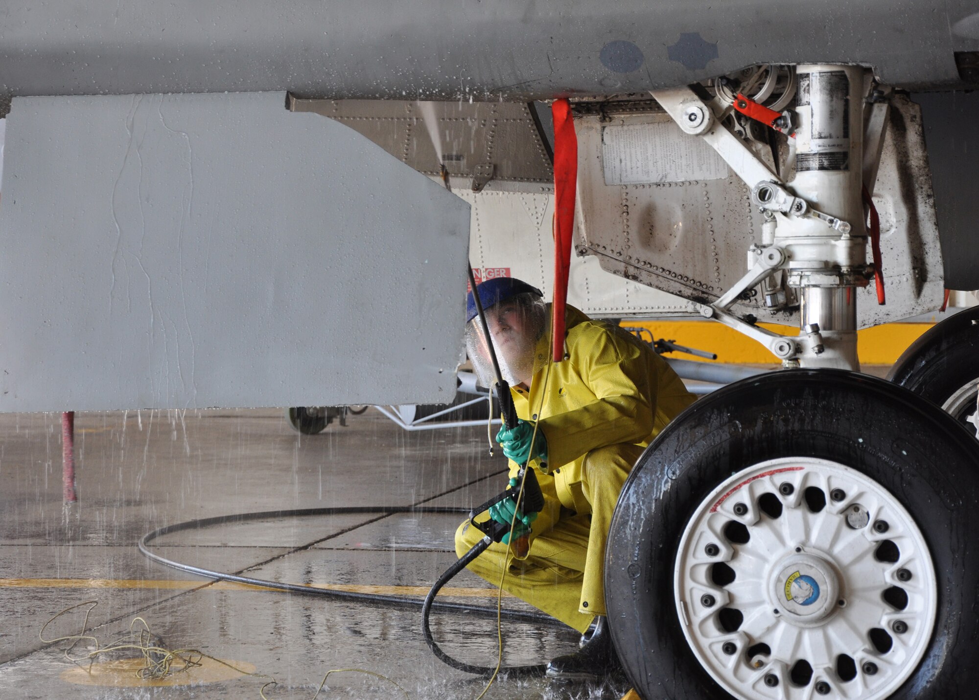 Senior Airman Tony Deaton, 33rd Maintenance Squadron, sprays an F-15 free of any residual hydraulic fluid and grime during the process of getting the jet prepared to be a static display for the Northwest Florida regional airport. The aircraft is the second of two 33rd Fighter Wing aircraft to be demilitarized so that it may be put on permanent display. Recently another jet was shipped to the USS Alabama battleship museum.  To make sure it is safe for public use, maintainers gut the aircraft's weapons, explosive devices, ejection seat, engine and anything that holds fluid or is potentially hazardous. After the wash, they will spend one week sealing all openings and another week painting the aircraft.  (U.S. Air Force photo/ Chrissy Cuttita.) 
