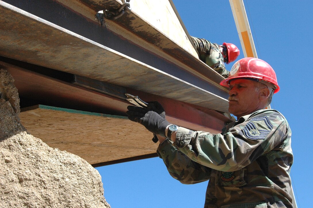 Senior Master Sgt. Larry Boyer, 201st REDHORSE SQuadron, completes securing an I-beam near the border.  The beam is a part of a shooting range for U.S. Customs and Border patrol agents who will use it to hone their skills and protect our nation.  (Photo by Capt. Jay Ostrich)