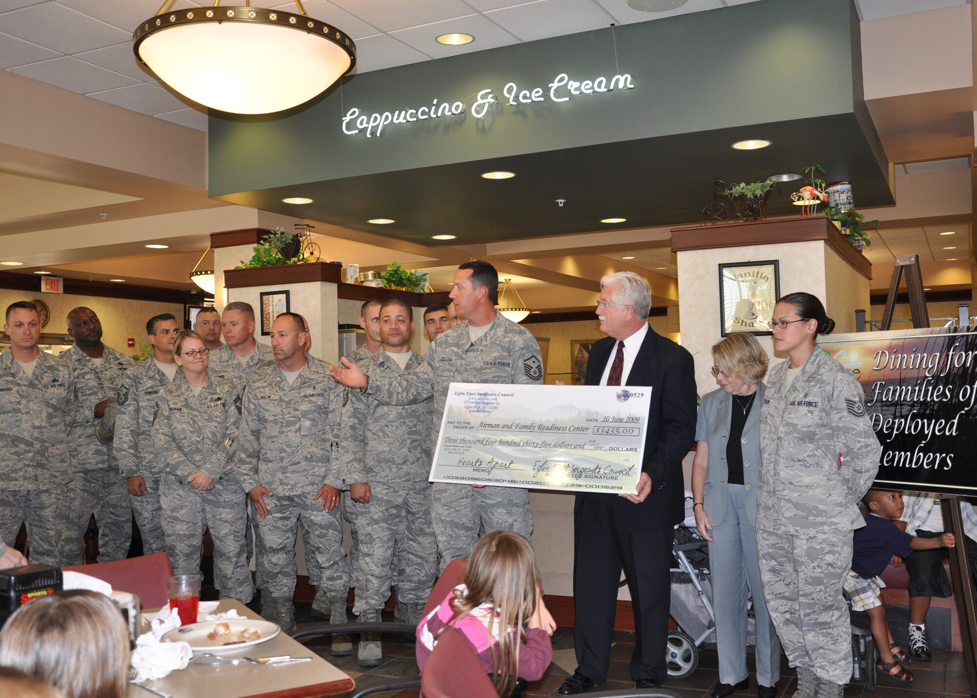 Members of the Airmen and Family Readiness Center accept a $3435 check for the Hearts Apart program from base first sergeants.  The first sergeants held a golf tournament fundraiser for the program in May.  The Hearts Apart program helps provide outreach and services to military, Department of Defense civilians and family members who are, will be or have been separated because of military commitments (deployments, temporary duties, remote tours).  (U.S. Air Force photo/Samuel King Jr.) 

