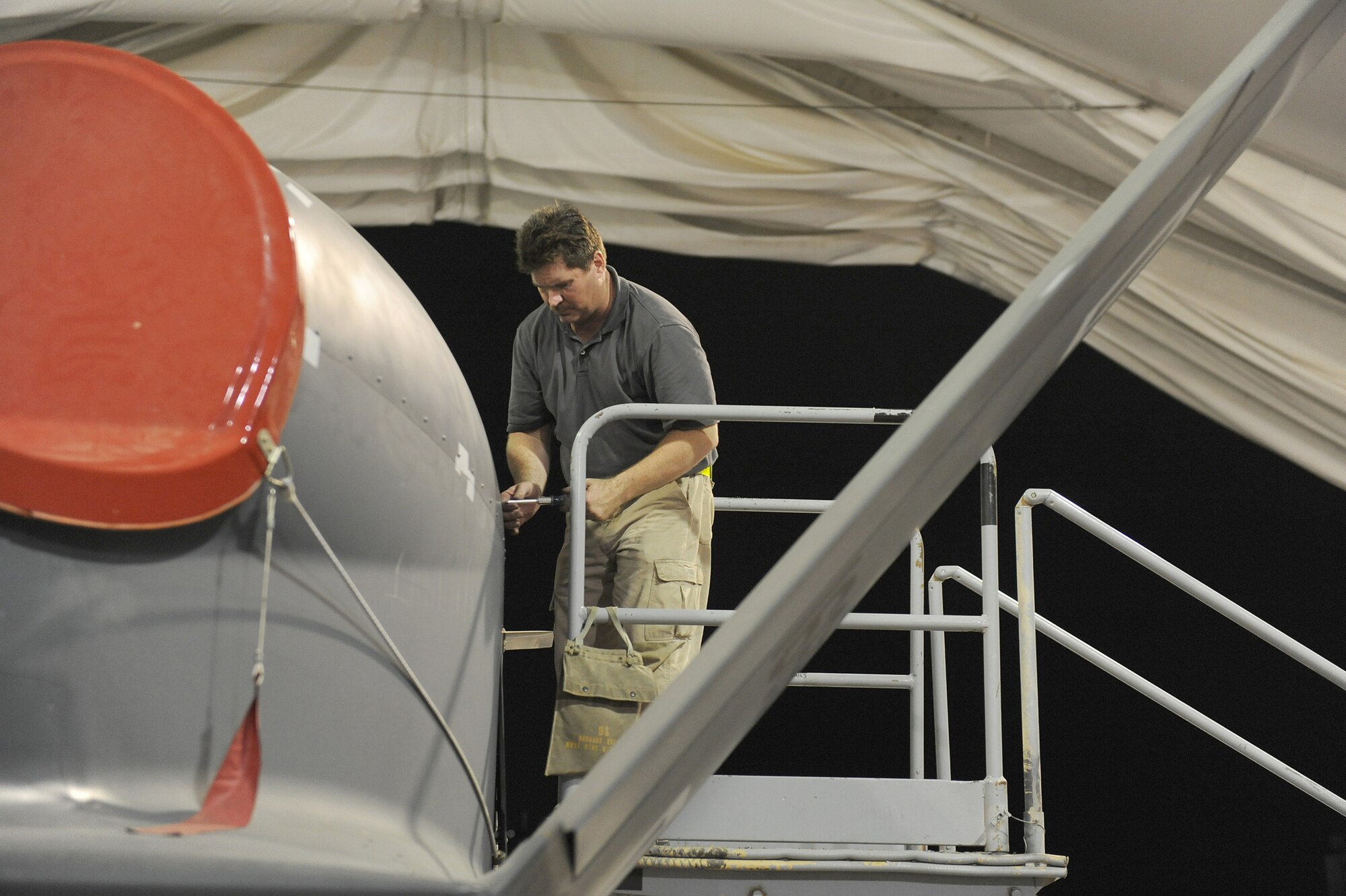 SOUTHWEST ASIA - Mr. Nate Cox, a Northrop Grumman contractor, tightens down an engine hatch on a Navy RQ-4 Global Hawk, June 10 at an undisclosed location in Southwest Asia. The Navy Global Hawk was being inspected at its 150 flying hours. The Navy Global Hawk is a key factor in maritime surveillance and reconnaissance keeping our Soldiers, Sailors, Marines and Airmen safe. (U.S. Air Force photo by Senior Airman Brian J. Ellis) (Released)