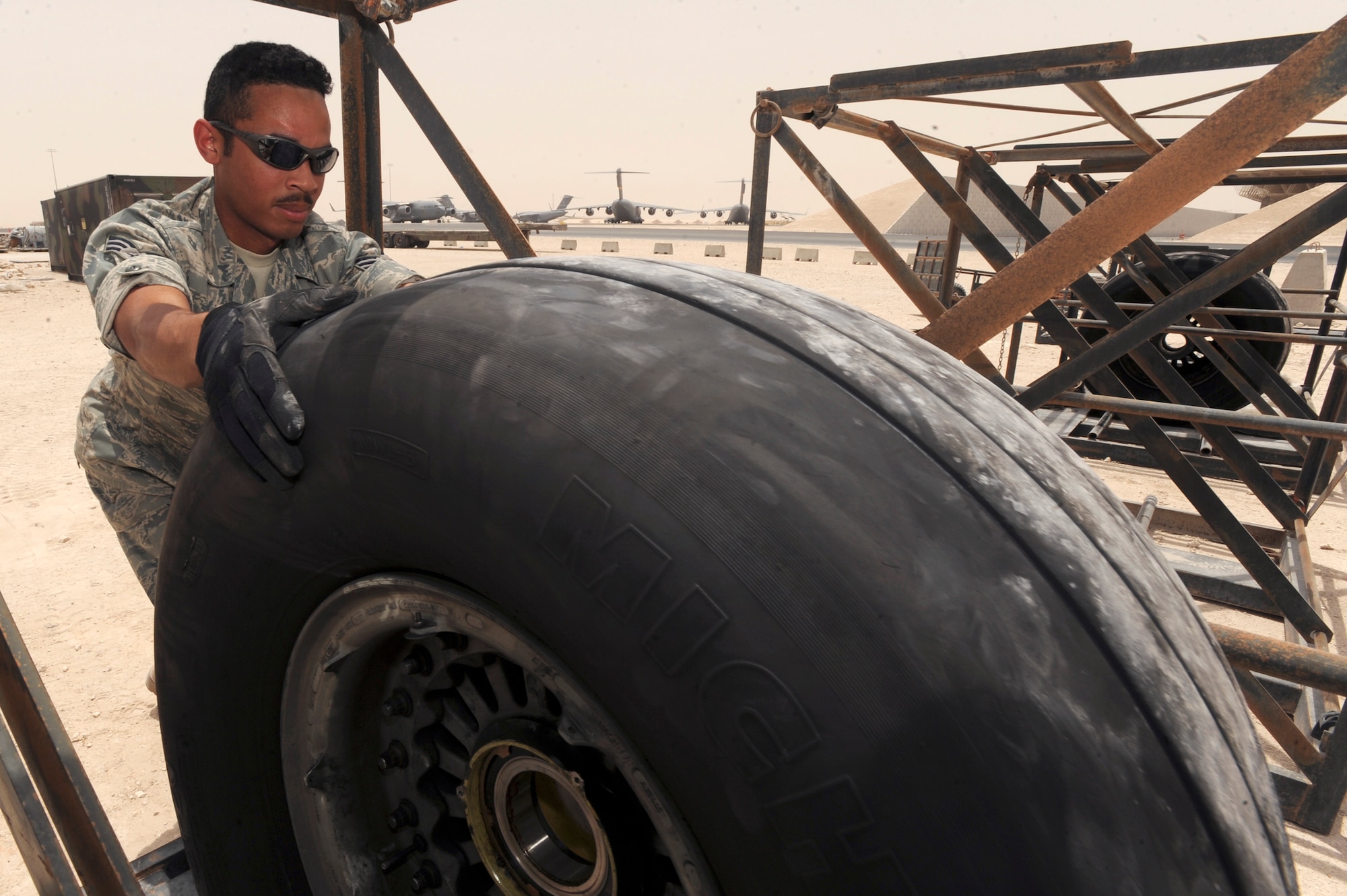 Senior Airman Luis Olivencia, a readiness spares package journeyman with the 8th Expeditionary Air Mobility Squadron places an unserviceable C-17 Globemaster III tire into a tire rack here, June 10, 2009, in and undisclosed location in Southwest Asia.  The racks are used to store aircraft tires prior to palletizing them for shipment.  Airman Olivencia is native to Norwalk, Conn. and is deployed from Dover Air Force Base, Del., in support of Operations Iraqi and Enduring Freedom and Combined Joint Task Force - Horn of Africa.  (U.S. Air Force Photo by Staff Sgt. Joshua Garcia/released)