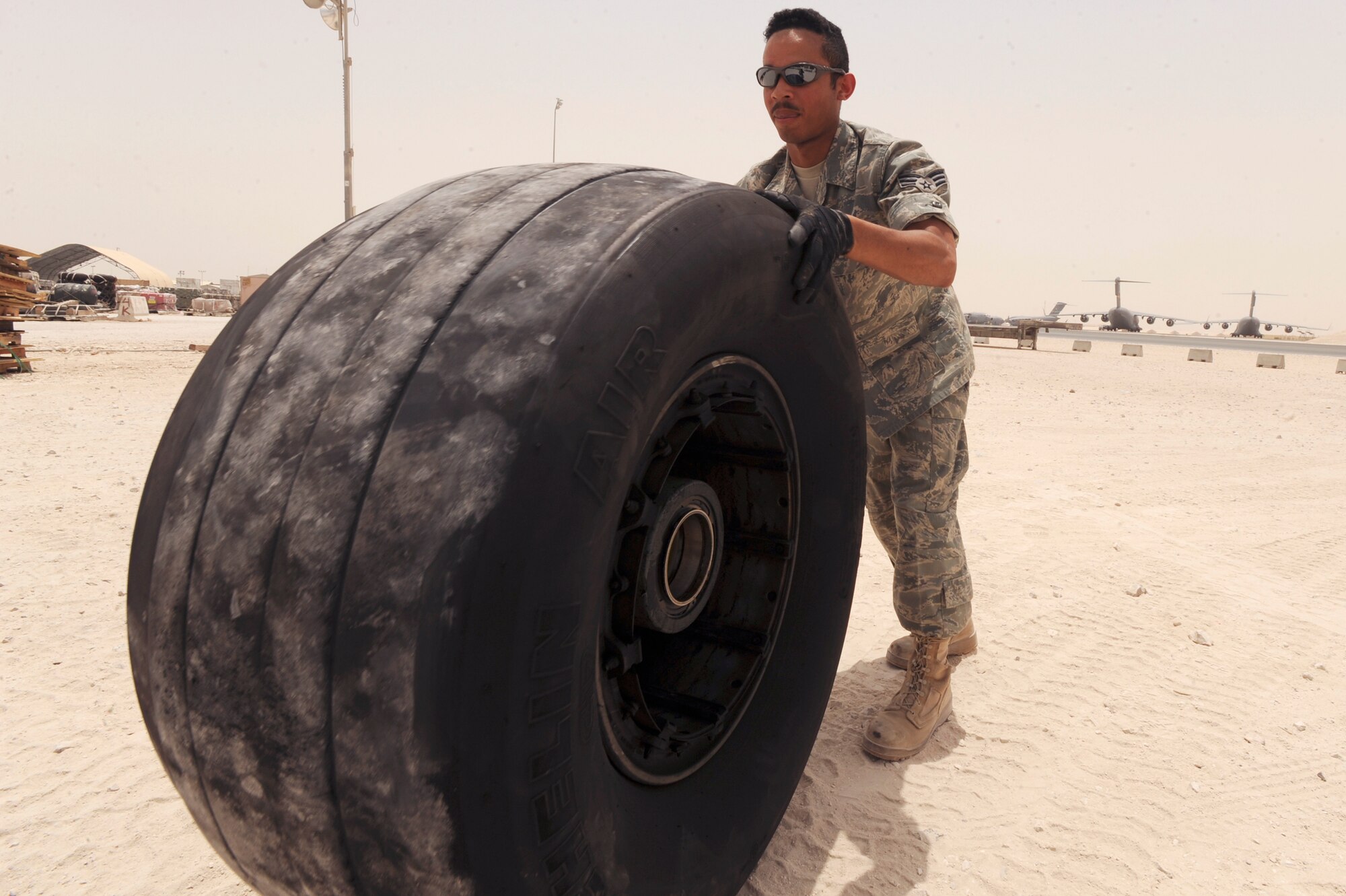 Senior Airman Luis Olivencia, a readiness spares package journeyman with the 8th Expeditionary Air Mobility Squadron transfers an unserviceable C-17 Globemaster III tire so it can be palletized and shipped out, June 10, 2009, in and undisclosed location in Southwest Asia. The wheels and tires are hand rolled from holding areas to the pallets to be processed for shipment.  Airman Olivencia is native to Norwalk, Conn. and is deployed from Dover Air Force Base, Del., in support of Operations Iraqi and Enduring Freedom and Combined Joint Task Force - Horn of Africa.  (U.S. Air Force Photo by Staff Sgt. Joshua Garcia/released)