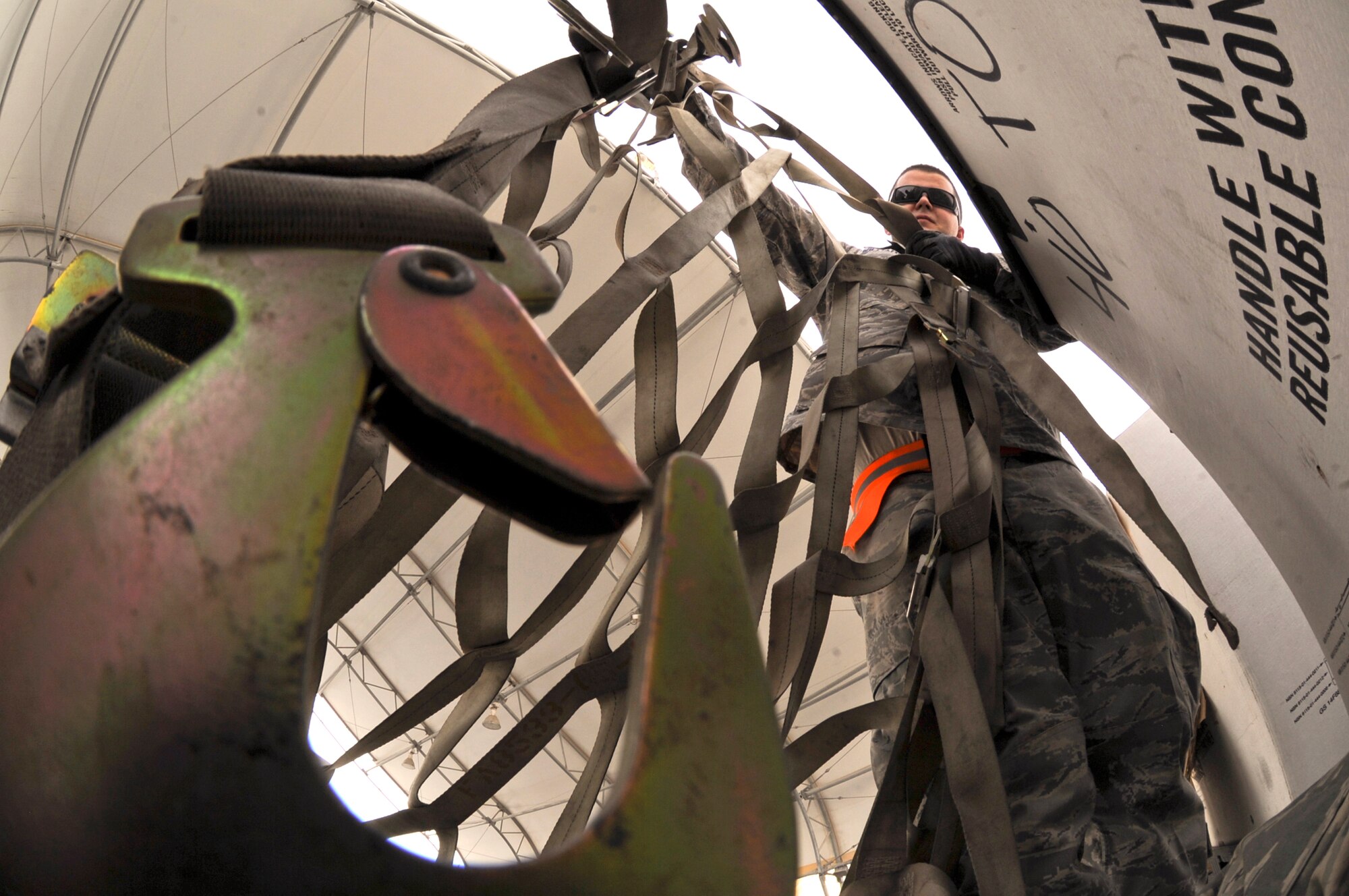 Airman 1st Class Kody Williams, a cargo processing specialist with the 8th Expeditionary Air Mobility Squadron, puts a cargo net on a piece of equipment after building a pallet here, June 9, 2009, in and undisclosed location in Southwest Asia.  After a pallet is built its contents are secured to the pallet by the cargo netting to ensure it will not move around while on the aircraft.  Airman Williams is native to Gainesville Fla. and is deployed from Pope Air Force Base, N.C., in support of Operations Iraqi and Enduring Freedom and Combined Joint Task Force - Horn of Africa.  (U.S. Air Force Photo by Staff Sgt. Joshua Garcia/released)