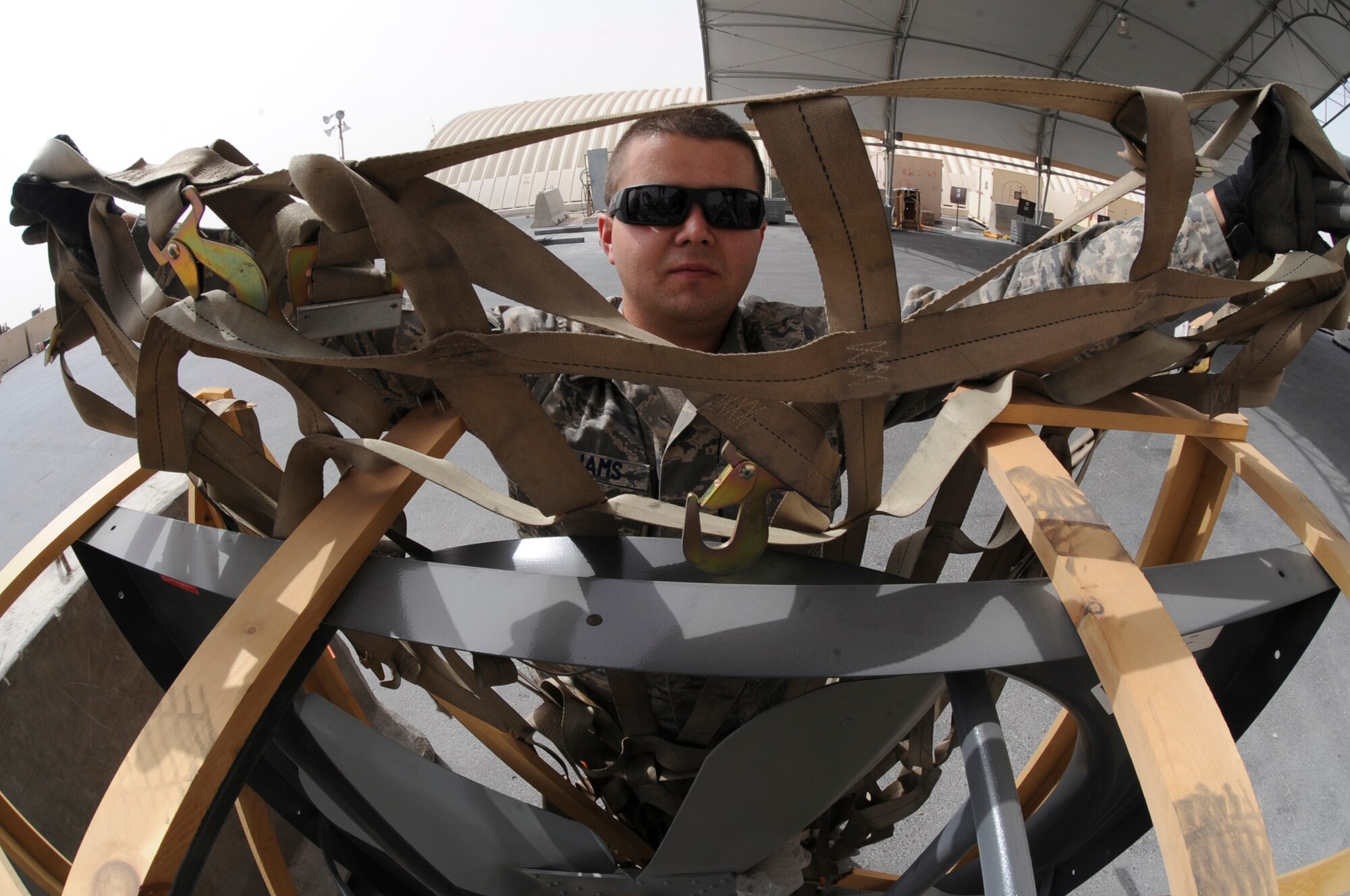 Airman 1st Class Kody Williams, a cargo processing specialist with the 8th Expeditionary Air Mobility Squadron, puts a cargo net on a piece of equipment after building a pallet here, June 9, 2009, in and undisclosed location in Southwest Asia.  Members of 8 EAMS handle all transitional equipment as well as transient personnel coming to and from the U.S. Central Command's area of responsibility. Airman Williams is native to Gainesville Fla. and is deployed from Pope Air Force Base, N.C. in support of Operations Iraqi and Enduring Freedom and Combined Joint Task Force - Horn of Africa.  (U.S. Air Force Photo by Staff Sgt. Joshua Garcia/released)