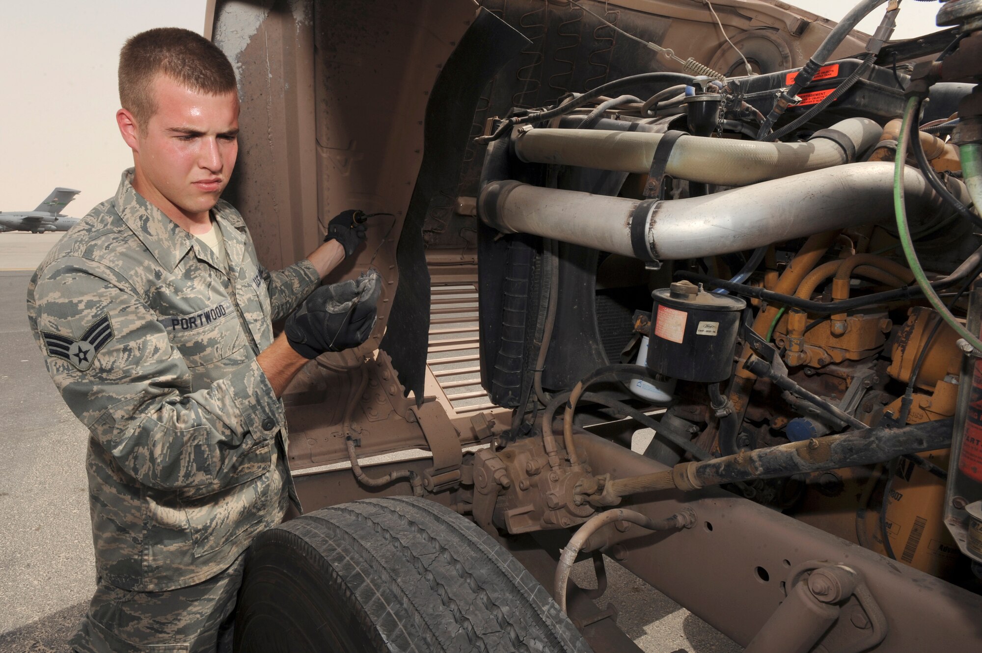 Senior Airman Clinton Portwood, a vehicle control manager for the 8th Expeditionary Air Mobility Squadron, checks the oil of a 10 ton tractor during a vehicle inspection here, June 9, 2009, in an undisclosed location in Southwest Asia.  Airman Portwood and fellow VCM's are accountable for all vehicles within their section of the squadron and ensure they all run efficiently to support the mission. Airman Portwood is native to Atlanta, Ga. and is deployed from Charleston Air Force Base, S.C., in support of Operations Iraqi and Enduring Freedom and Combined Joint Task Force - Horn of Africa.  (U.S. Air Force Photo by Staff Sgt. Joshua Garcia/released)