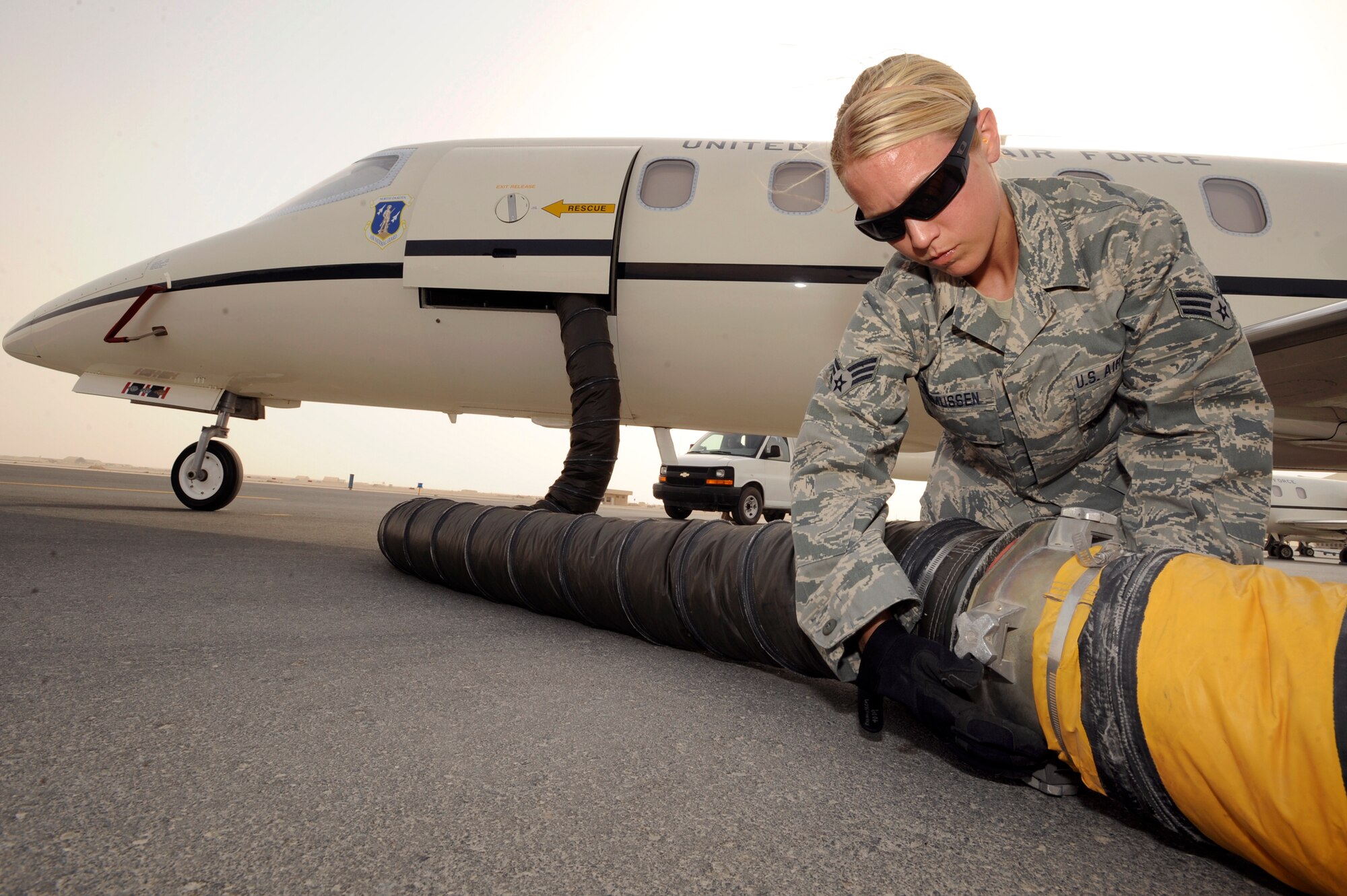 Senior Airman Sarah Rasmussen, an aircraft mechanic with the 119th Aircraft Maintenance Unit, connects air conditioning hoses to the main cabin of a C-21 aircraft, June 10, 2009 in an undisclosed location in Southwest Asia.  Prior to a mission the cabin is cooled to ensure a comfortable climate for distinguish visitors upon entering the aircraft.  Airman Rasmussen hails from Moorehead, Minn. and is deployed from the North Dakota Air National Guard in support of Operations Iraqi and Enduring Freedom and Combined Joint Task Force - Horn of Africa.  (U.S. Air Force Photo by Staff Sgt. Joshua Garcia/released)