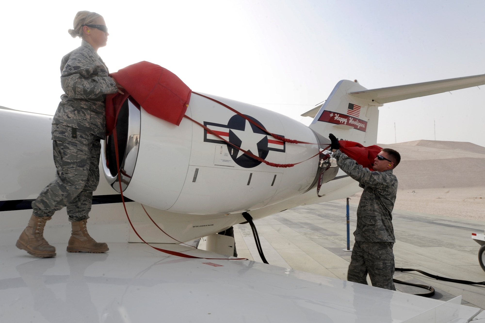 Senior Airman Sarah Rasmussen, and Tech. Sgt. Darby Plath both aircraft mechanics with the 119th Aircraft Maintenance Unit, remove the engine cover from a C-21 aircraft during a preflight inspection, June 10, 2009, in an undisclosed location in Southwest Asia.  The main mission of the 379the Expeditionary Operations Group C-21 fleet is to transport distinguished visitors to locations within the U.S. Central Command's area of responsibility. Airman Rasmussen is native to Moorehead, Minn. and Sergeant Plath hails from Fargo, N.D., both are deployed from the North Dakota Air National Guard in support of Operations Iraqi and Enduring Freedom and Combined Joint Task Force - Horn of Africa.  (U.S. Air Force Photo by Staff Sgt. Joshua Garcia/released)