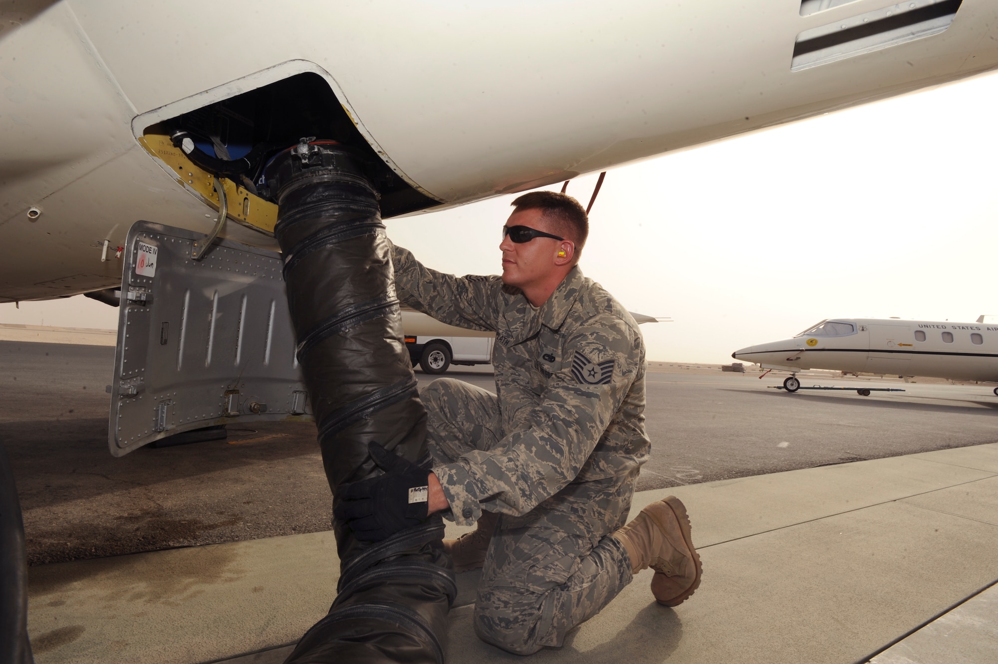 Tech. Sgt. Darby Plath, an aircraft mechanic with the 119th Aircraft Maintenance Unit, positions an air conditioning duct to cool off the C-21 battery compartment prior to another mission, June 10, 2009, in an undisclosed location in Southwest Asia.  The aircraft batteries are cooled prior to pilots stepping to the aircraft to ensure an expedient preflight. Sergeant Plath hails from Fargo, N.D. and is deployed from the North Dakota Air National Guard, in support of Operations Iraqi and Enduring Freedom and Combined Joint Task Force - Horn of Africa.  (U.S. Air Force Photo by Staff Sgt. Joshua Garcia/released)