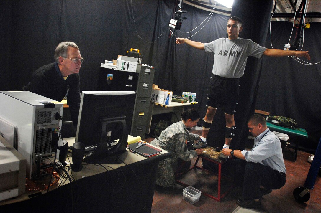 Army Sgt. Michael Cavallo, a research assistant at the U.S. Army Research Institute of Environmental Medicine, Natick, Mass., is fitted May 6, 2009, with sensors that will be detected by infrared cameras as he walks on a patented, force-sensing treadmill invented by those at the lab. The sensors capture his movements and translate it to data and the treadmill measures the force placed on his body while shouldering a load. 