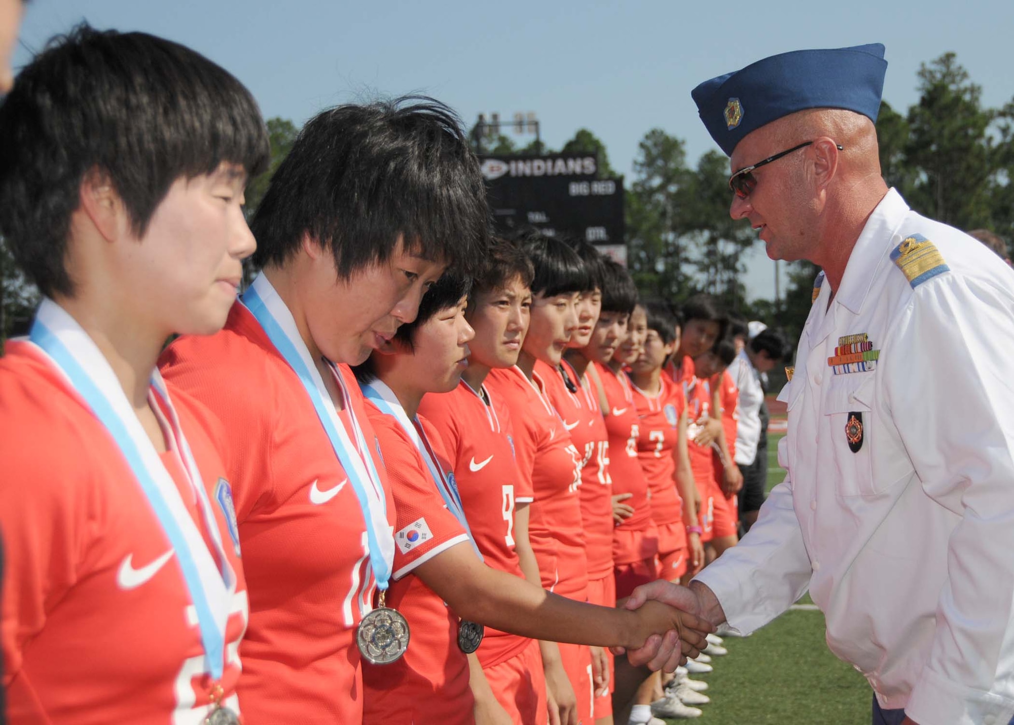 Col. Stefan Marginean of Romania, member of the Conseil International du Sport Militaire board of directors and official CISM representative, presents the CISM silver medal to the seconc-place team from the Republic of South Korea at the closing ceremonies of the 5th CISM Women’s Soccer Championship at the Biloxi High Stadium, June 13.  Brazil earned the gold medal and The Netherlands took the bronze medal.  The CISM tournament, hosted by Keesler Air Force Base, also included teams from France, Canada, Germany and the United States.  (U.S. Air Force photo by Kemberly Groue)