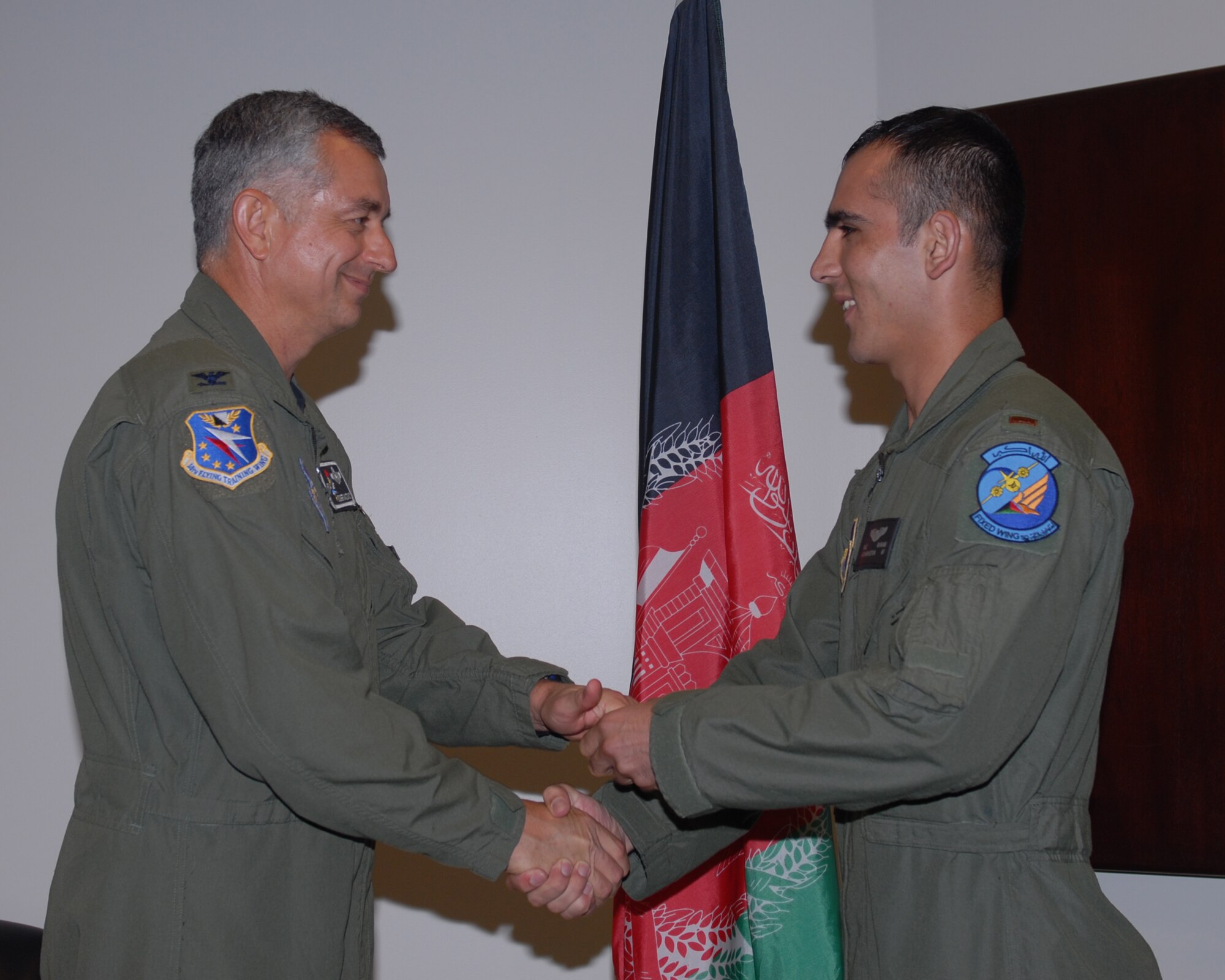 Col. Roger Watkins, 14th Flying Training Wing commander, presents Afghan National Army Air Corps Lt. Faiz Ramaki his Air Force silver wings at a special Aviation Leadership Program ceremony Friday. (US Air Force Photo/Melissa Duncan)