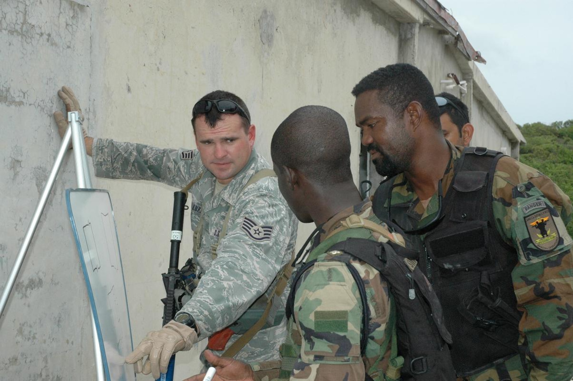 Staff Sgt. Kyle Luker (far left), 820th Security Forces Group, Moody
AFB, GA, provides instruction on building entry procedures to 2nd Lt. Javan
Simpson (center), and Sgt. Otis Harris, 3rd Battalion, Jamaican Defense
Force, during Close Quarters Battle training Monday near Kingston, Jamaica.
Luker and more than 60 other personnel of various specialties are
participating in Operation Southern Partner, a cooperative exchange program
between the U.S Air Force and the defense forces of Belize, Jamaica,
Grenada, Guyana, St. Lucia, Trinidad and Tobago. (U.S. Air Force photo by
Kevin Walston)