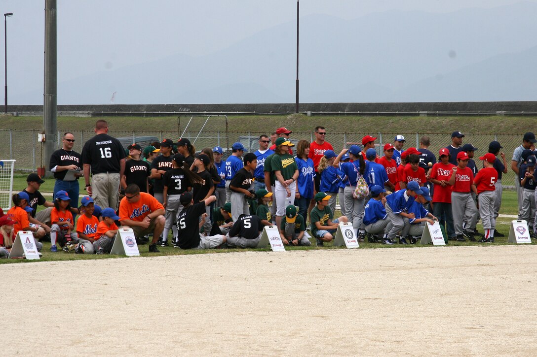 Players and coaches from all 21 teams wait in anticipation on the edge of the infield to have their team called to the pitcher’s mound to receive trophies during the 2009 Youth Baseball closing ceremony at Penny Lake::r::::n::here June 13. The baseball season was open to station residents as well as Japanese nationals between the ages of 3-12.