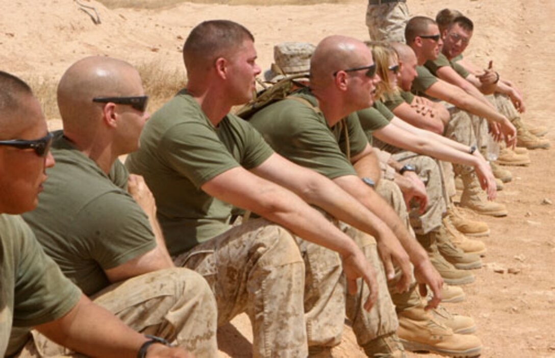 Marines from Marine Fighter Attack Squadron 314 relax while their teammate completes the gator pull event during a field meet aboard Al Asad Air Base, Iraq, June 14, 2009. The sun was abundant and the shade was limited, but the resting places were endless. (U.S. Marine Corps photo by Lance Cpl. Holly McChesney)::r::::n::::r::::n::