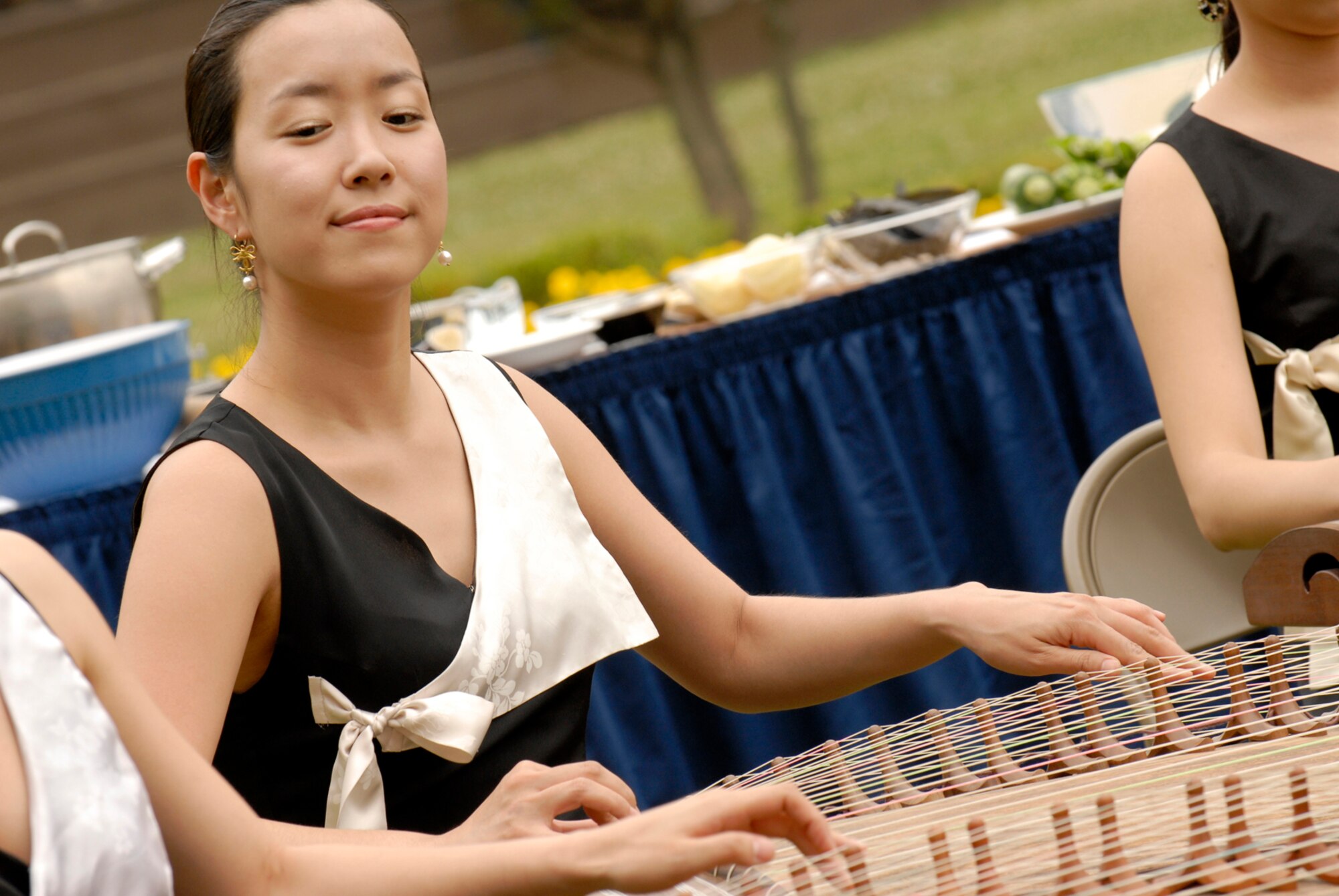 A South Korean musician plays a Korean harp (Gayageum) during the filming of Delicious Korea (Dae Han Min Guk), June 8. The South Korean television studio filmed Team Osan members as they prepared traditional South Korean meals. This is
the first time United States military members have been in the show. (U.S. Air Force photo/Senior Airman Stephenie Wade).