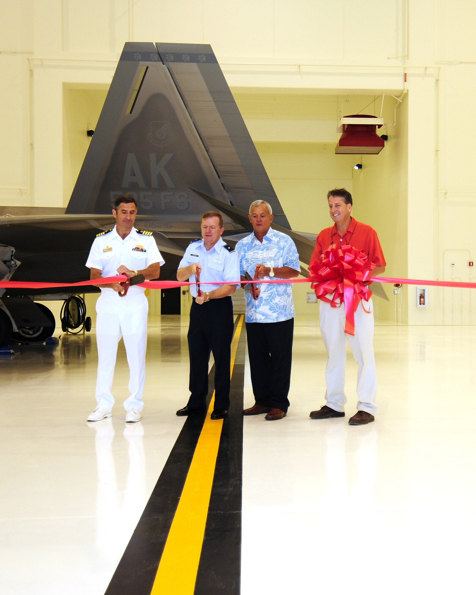ANDERSEN AIR FORCE BASE, Guam - Capt. Paul Fuligni, commander Naval Facilities Engineering Command Marianas, Brig. Gen. Phil Ruhlman 36th Wing commander, and Leonard Kaae, senior vice president and general manager of Black Construction, cut the ribbon June 12 officially opening Hangar 6.  Hangar 6 is the future home of the Global Hawk unmanned aerial vehicle.   (U.S. Air Force photo by Tech. Sgt. Michael Boquette)
