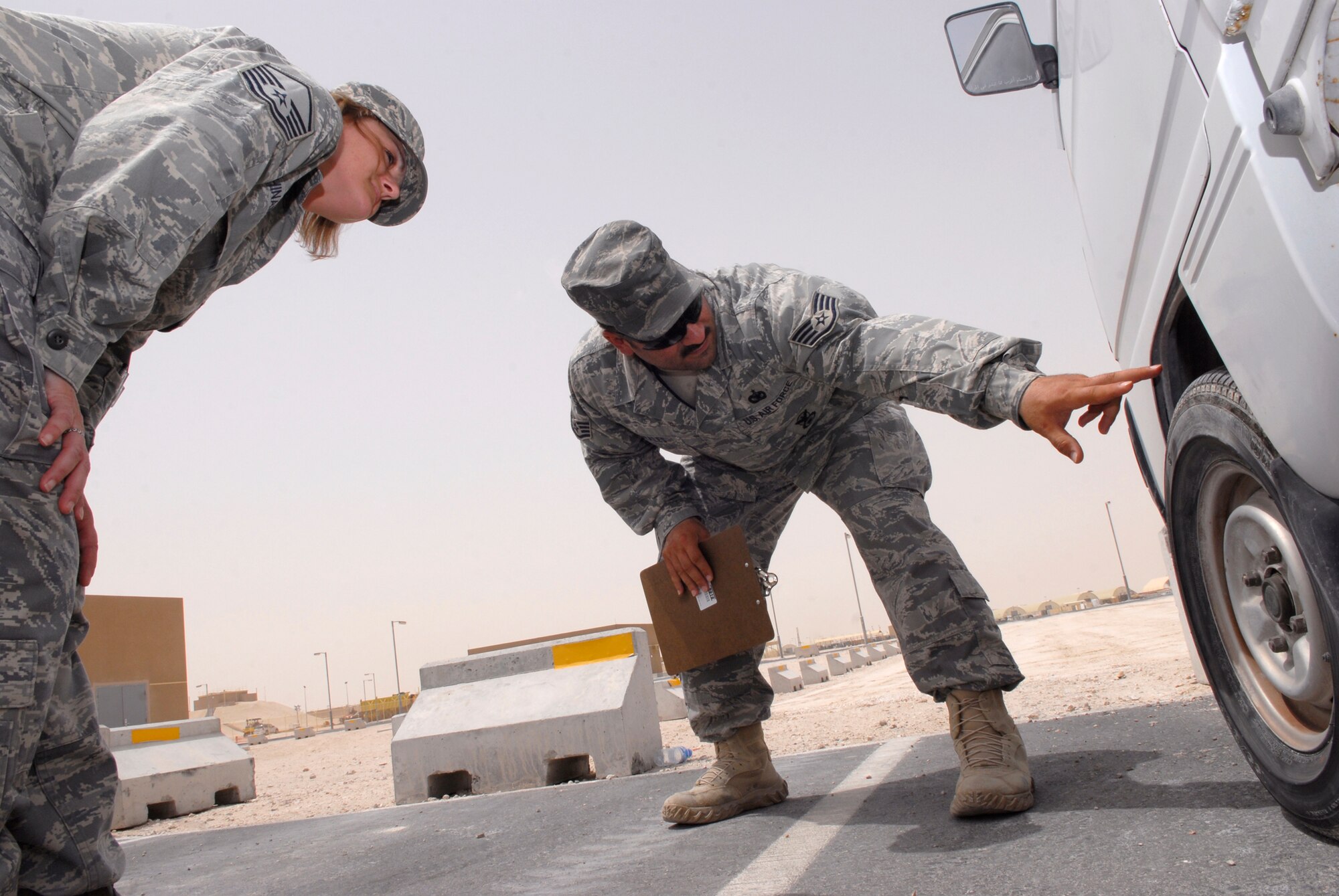 Staff Sgt. Jason Morales, 379th Air Expeditionary Wing Force Protection NCO in charge, points out areas to look for during a spot inspection with Master Sgt. Diana Shinabarger, 379th Expeditionary Operations Group command section superintendent, during her unit's scheduled Random Antiterrorism Measure (RAM) inspection, June 9, 2009, at an undisclosed location in Southwest Asia.  Spot Inspections are conducted to help ensure the effectiveness of the Wing RAM Program and continues to improve it through direct feedback from personnel conducting the RAMs.  Sergeant Morales hails from Toms River, N.J. and is deployed from Ramstein Air Base, Germany.  Sergeant Shinabarger hails from Buffalo, N.Y. and is deployed from Langley Air Force Base, Va., both are deployed in support of Operations Iraqi and Enduring Freedom and Combined Joint Task Force - Horn of Africa.  (U.S. Air Force photo/Senior Airman Andrew Satran/released)