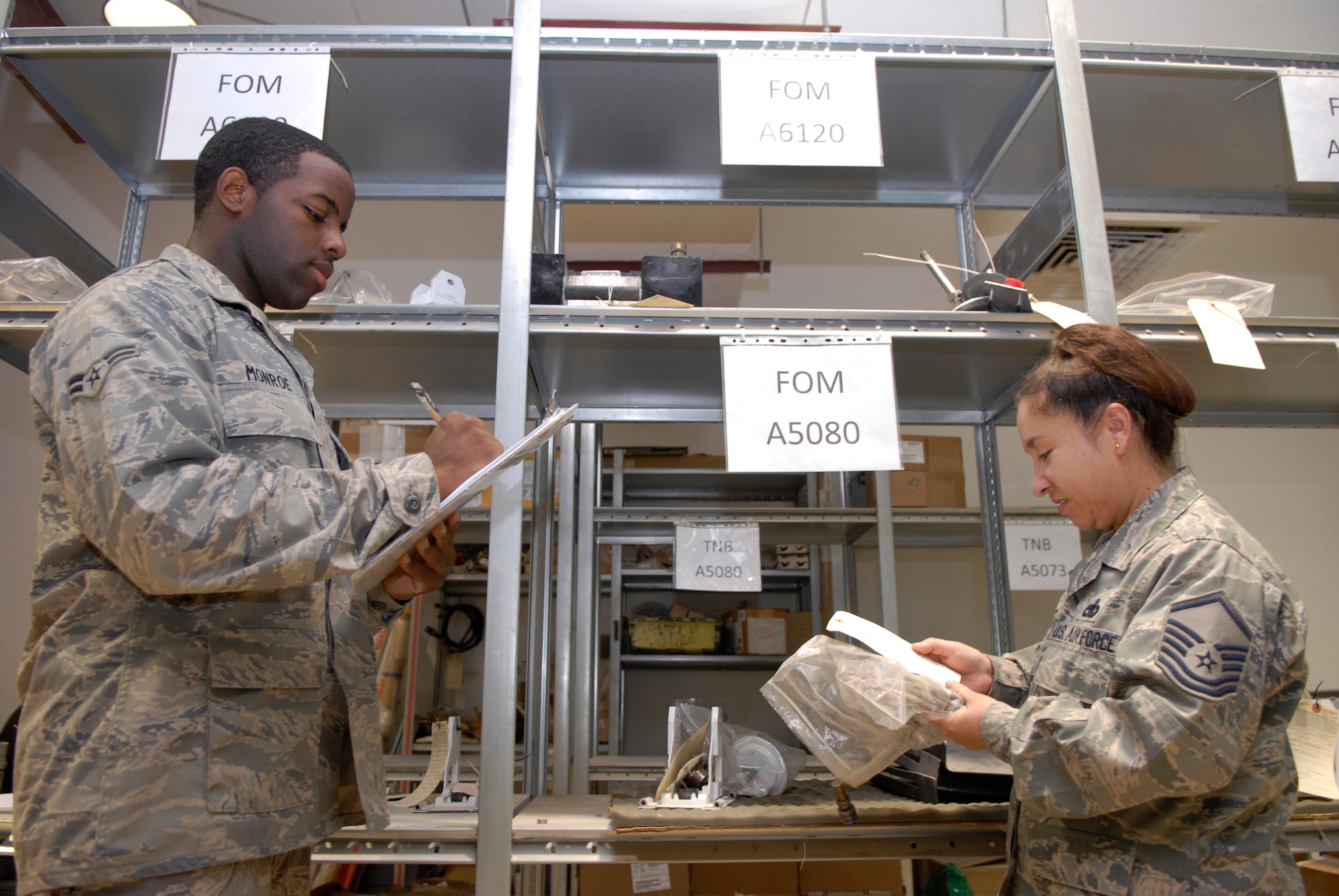 Airman 1st Class Derrick Monroe, 379th Expeditionary Aircraft Maintenance Squadron combat oriented supply organization (COSO) journeyman, and Master Sgt. Rose Elliot, 379th EAMXS COSO NCO in charge, inventory the tail number bin where parts are held until needed, June 9, 2009, at an undisclosed location in Southwest Asia.  COSO personnel manage and maintain unit's tail number bins and track items removed to assist maintenance technicians in the research of parts requested to perform their mission.  Airman Monroe hails from Albany, Ga.  Sergeant Elliot hails from Fort Wayne, Ind.  Both are deployed from Dyess Air Force Base, Texas, in support of Operations Iraqi and Enduring Freedom and Combined Joint Task Force - Horn of Africa.  (U.S. Air Force photo/Senior Airman Andrew Satran/released)