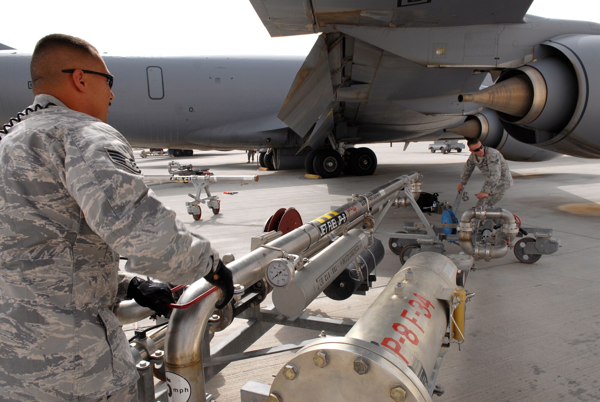 Staff Sgt. David Thomas, 379th Expeditionary Logistics Readiness Squadron (ELRS) fuels distribution supervisor, and Airman 1st Class Brandon Sullivan, a 379th ELRS fuels distribution operator, move a refueling pantograph into position to refuel a KC-135R Stratotanker, June 10, 2009, at an undisclosed location in Southwest Asia.  Airman Sullivan pumped 16,083 gallons of JP-8 fuel at 457 gallons per minute through the system to refuel the aircraft.  Fuel distribution operators deliver fuel to aircraft around the clock everyday of the year to meet the ongoing demands of the mission.  Sergeant Thomas hails from Mountain Ranch, Calif. and is deployed from Holloman Air Force Base, N.M.  Airman Sullivan hails from Burlington, Iowa and is deployed from Kadena Air Base, Japan.  Both are deployed in support of Operations Iraqi and Enduring Freedom and Combined Joint Task Force - Horn of Africa.  (U.S. Air Force photo/Senior Airman Andrew Satran/released)  