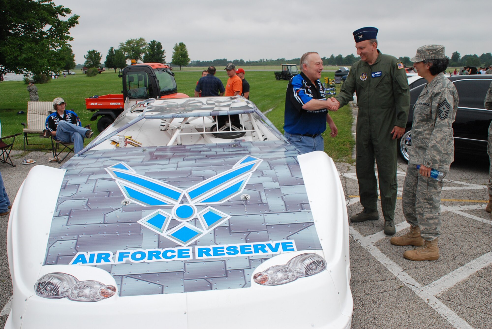 932nd Airlift Wing Command Chief Master Sgt. Sandra Santos (right) and 932nd Airlift Wing Vice Commander, Col. Jeff Johnson, (center) greet one of their retired wing members, Senior Master Sgt. Bob Salter, who now runs  "Salty Dog" race car team with family members in Illinois.  He brought the car to Scott Air Force Base for a recent picnic event.  (U.S. Air Force photo/Maj. Stan Paregien)