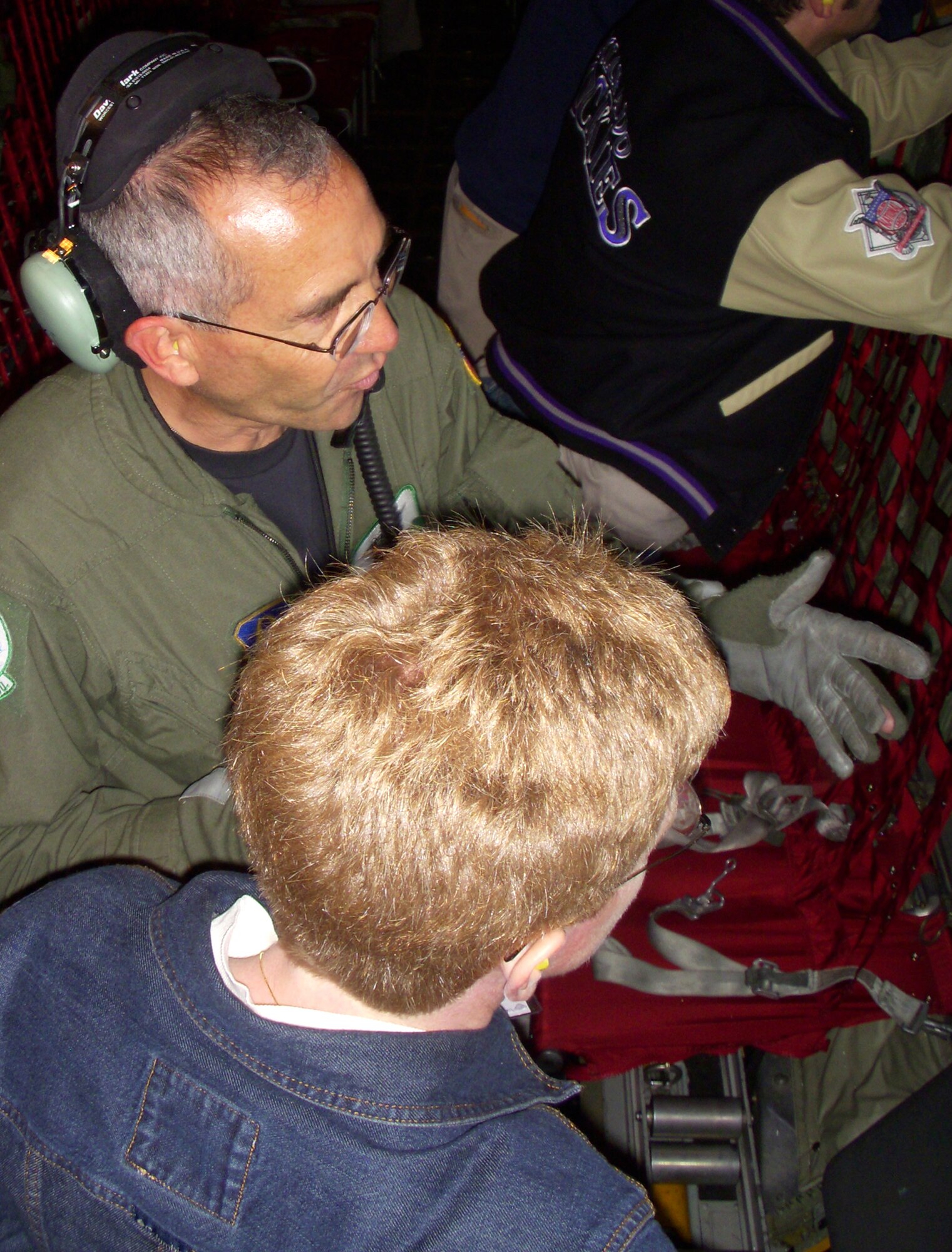 Master Sgt. Ken Valdez, a C-130 loadmaster, explains the inner workings of the tactical aircraft to Ms. Kate Hatten June 13 over the skies of southern Colorado. Ms. Hatten was one of 17 employers invited to attend the 302nd Airlift Wing's annual Employer Appreciation Day. The employers, who employ an Air Force reservist, were treated to an up close look of the wing, an orientation flight in a C-130 Hercules and a traditional meal at the base's dining facility. (U.S. Air Force photo/Senior Airman Stephen J. Collier)